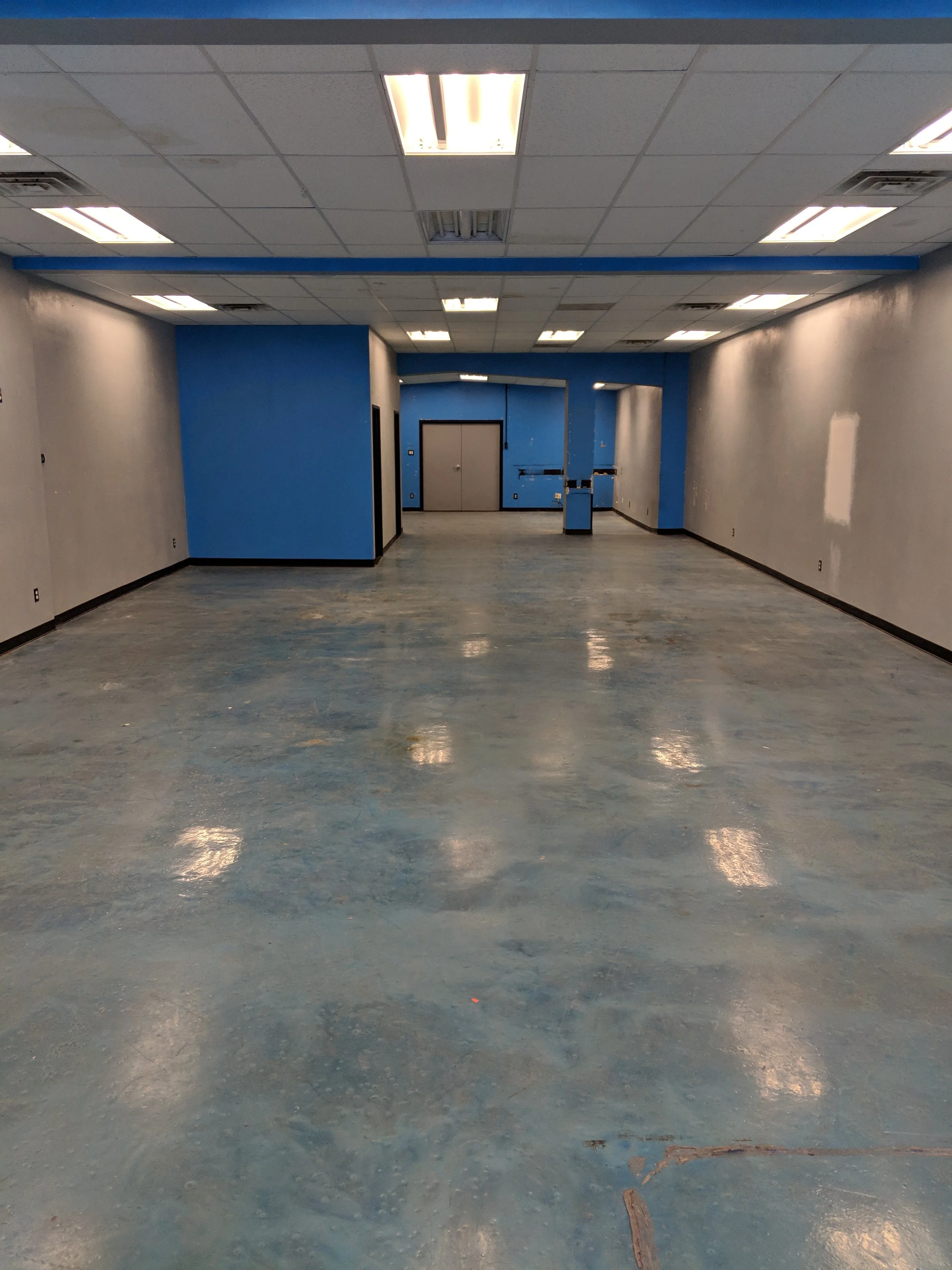 Interior of 4611-B showing the open showroom floorplan and rear doors