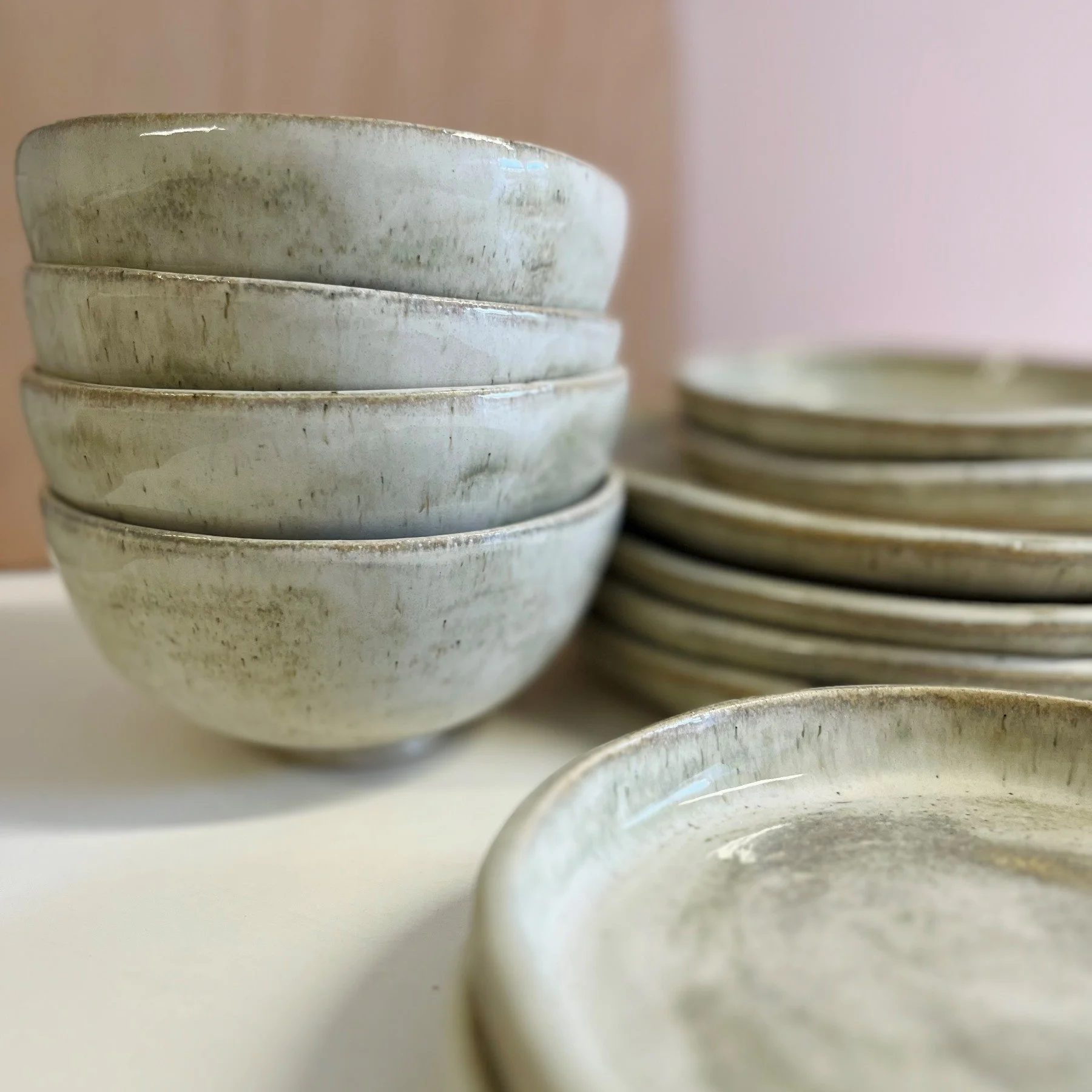Close-up view of stacked ceramic bowls with a speckled glaze.