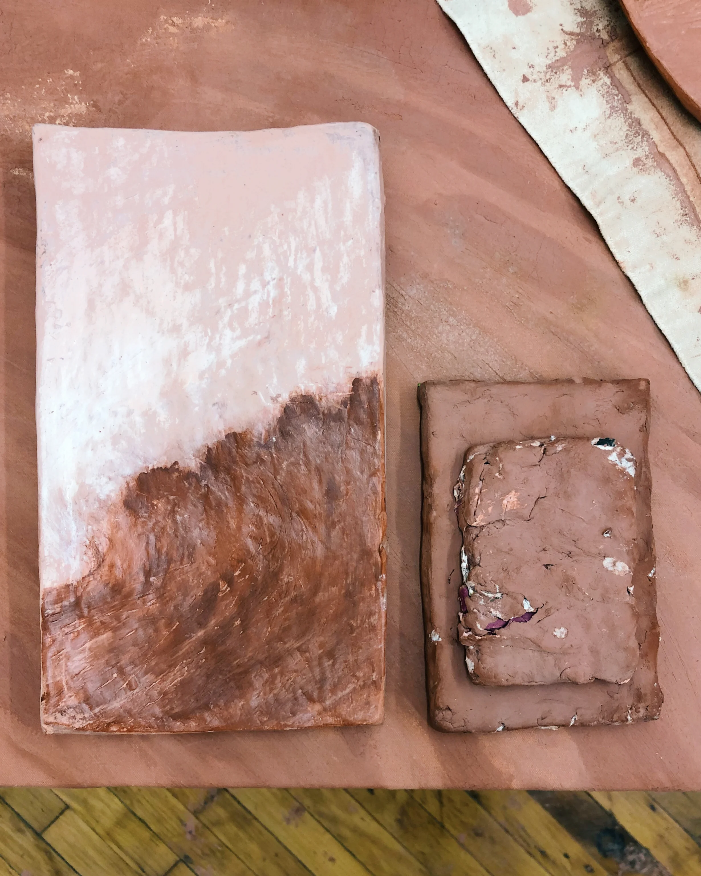 Clay tablets, painted, sculpted around torn book pages
