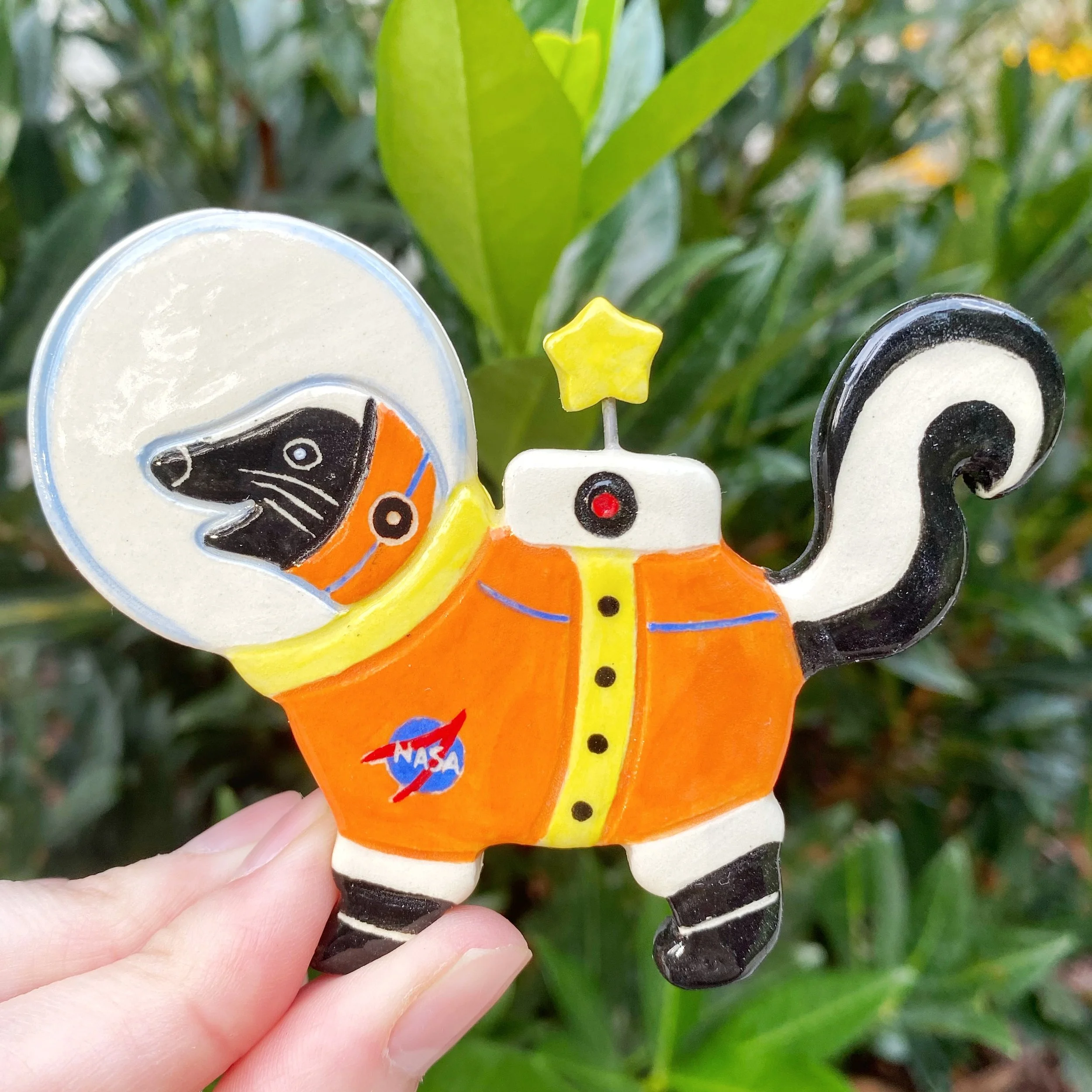 seconds_skunk_astronaut_orange_magnet_1.jpeg