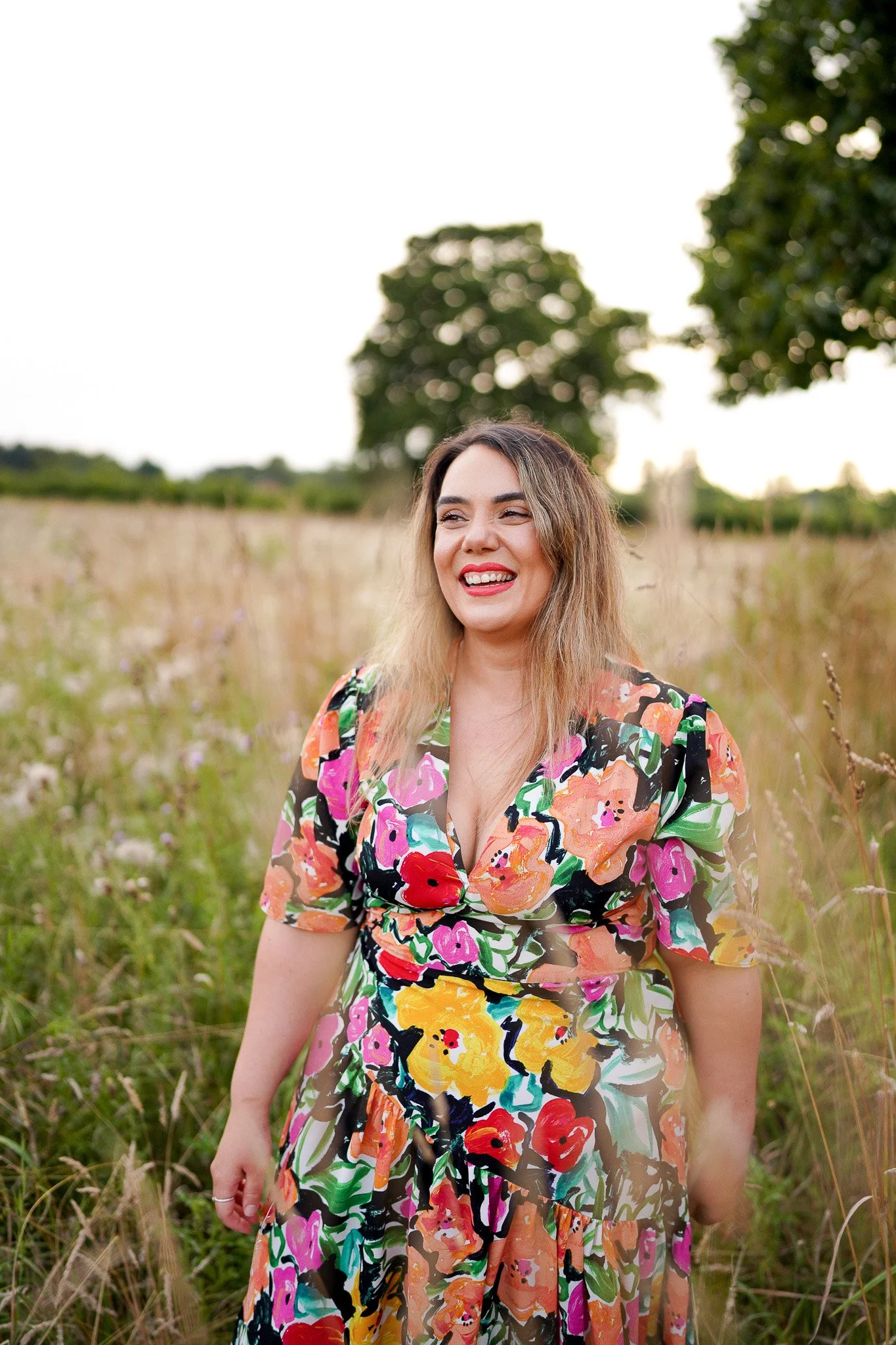 Outdoor portrait photoshoot at Dunham Massey gardens in Cheshire with subject posing among tall grass, flowers and historic landscapes