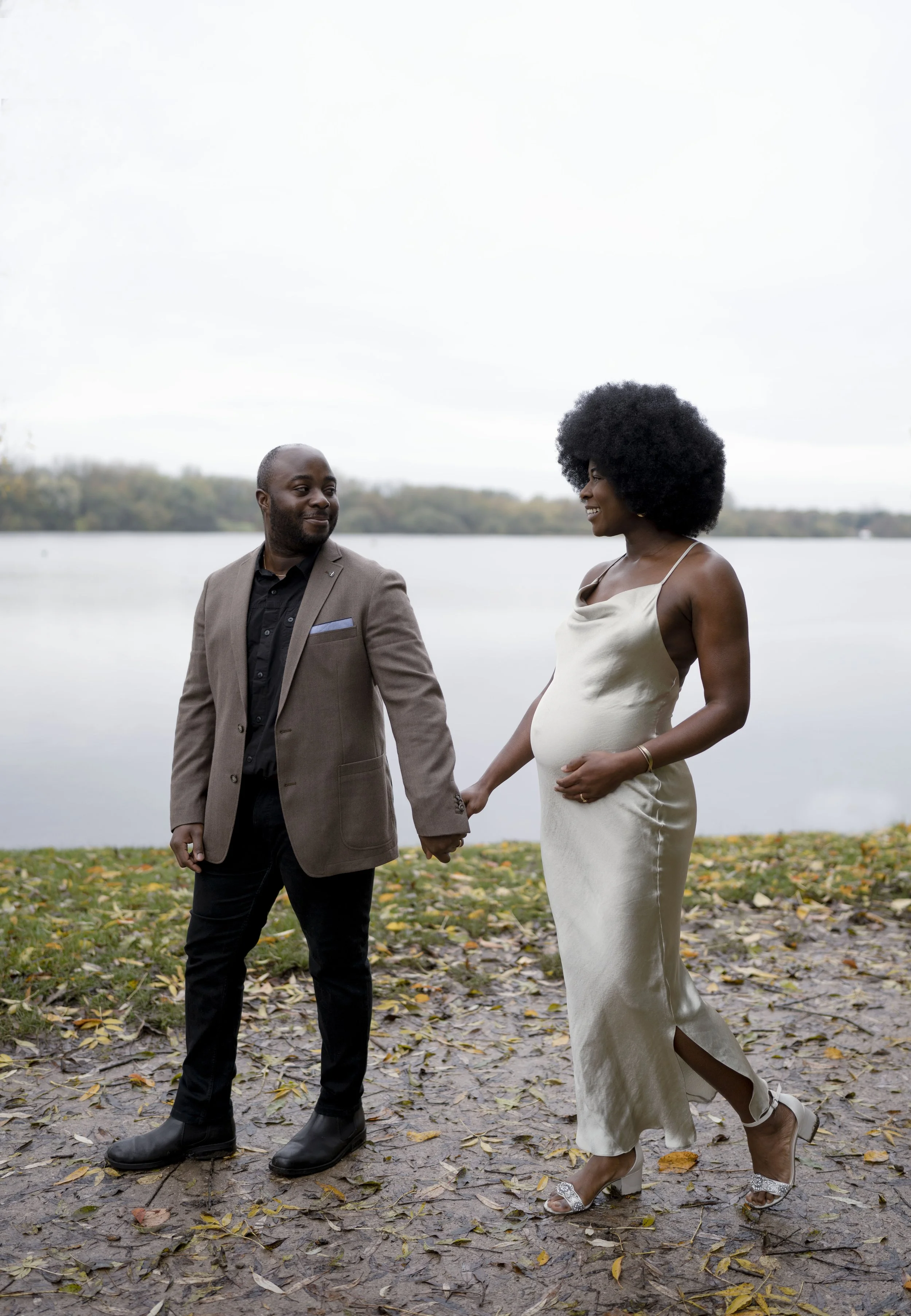 An expectant mother and her husband pose for photos next to a lake in Lancashire whilst on their maternity photoshoot