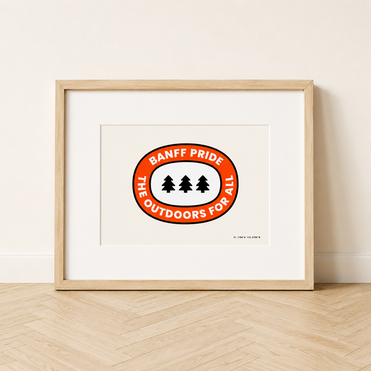 Outdoors For All 5x7 art print displayed with a white mat in a natural wood 8x10 frame, featuring a red Banff Pride outdoor badge and three evergreen trees.