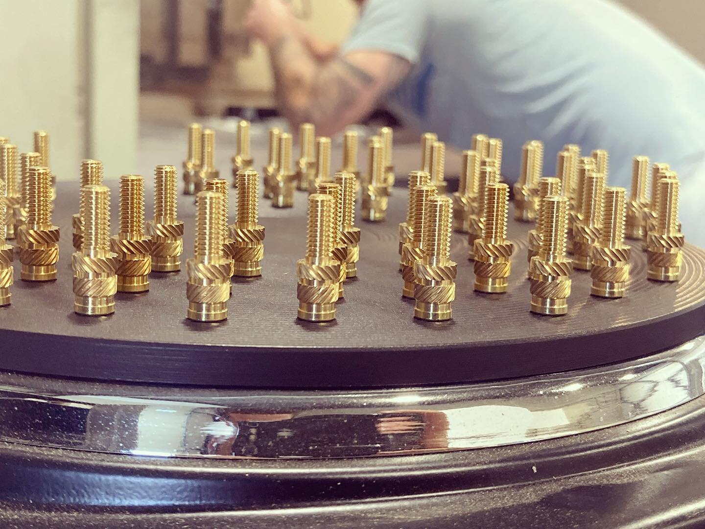 Brass heat-set inserts in Delrin.  Usually we're installing female inserts, yesterday we had some studs.  These take a lot of heat saturation to seat so they were preheated on the hotplate prior to pressing into the material.  Yes, the process is a l