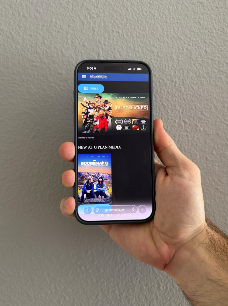Person holding a smartphone displaying a streaming media app featuring movies and TV shows.