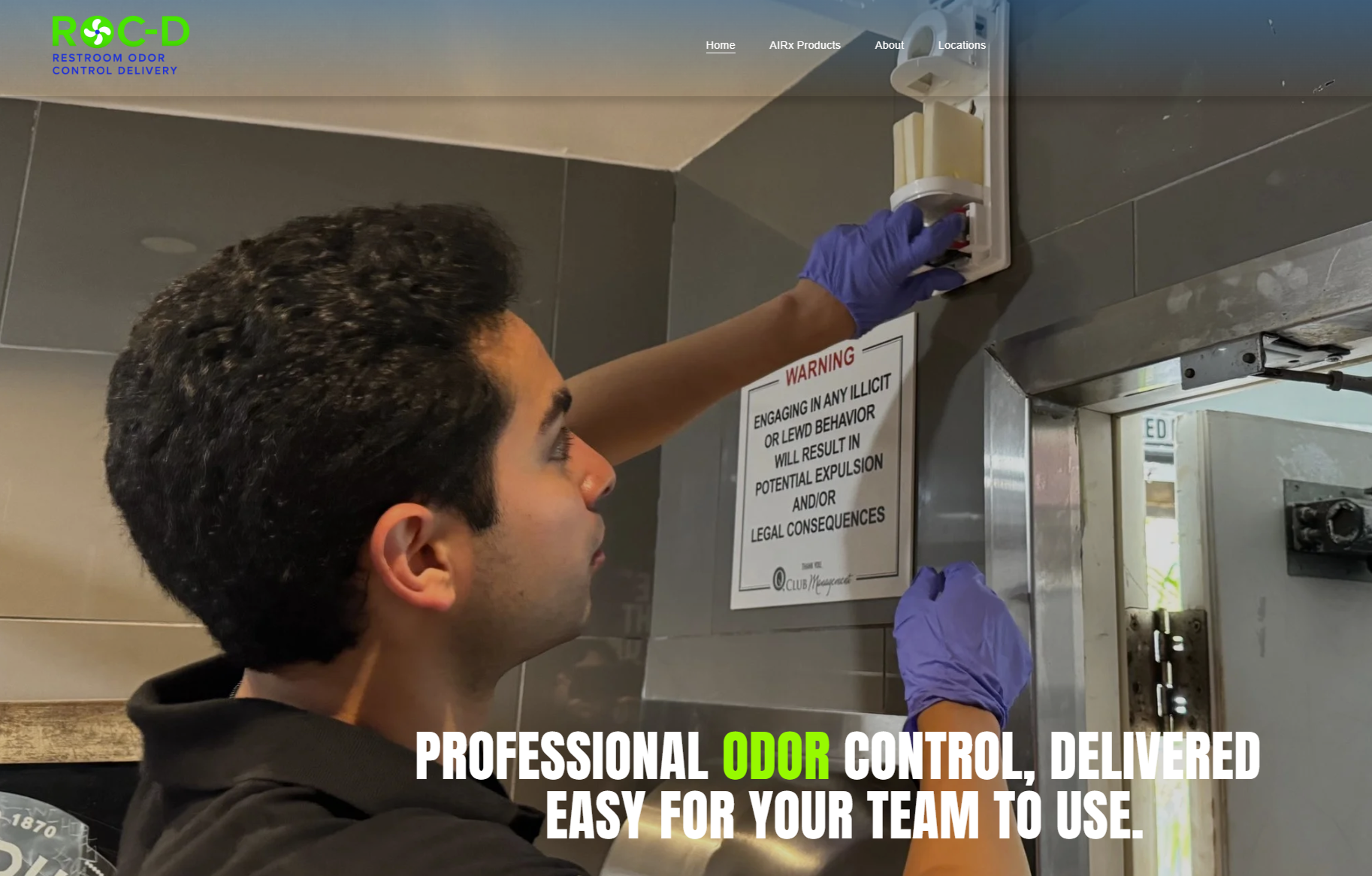 A man wearing blue gloves installing or adjusting an odor control device in a public restroom. There is a warning sign on the wall about illicit or lewd behavior and its legal consequences. The image includes the logo and slogan of a company that provides professional odor control delivery services.