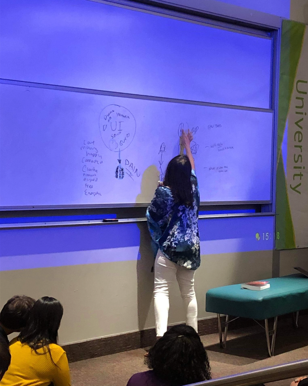 Dr. Sura Corrigan lecturing on chiropractic care for women at a university