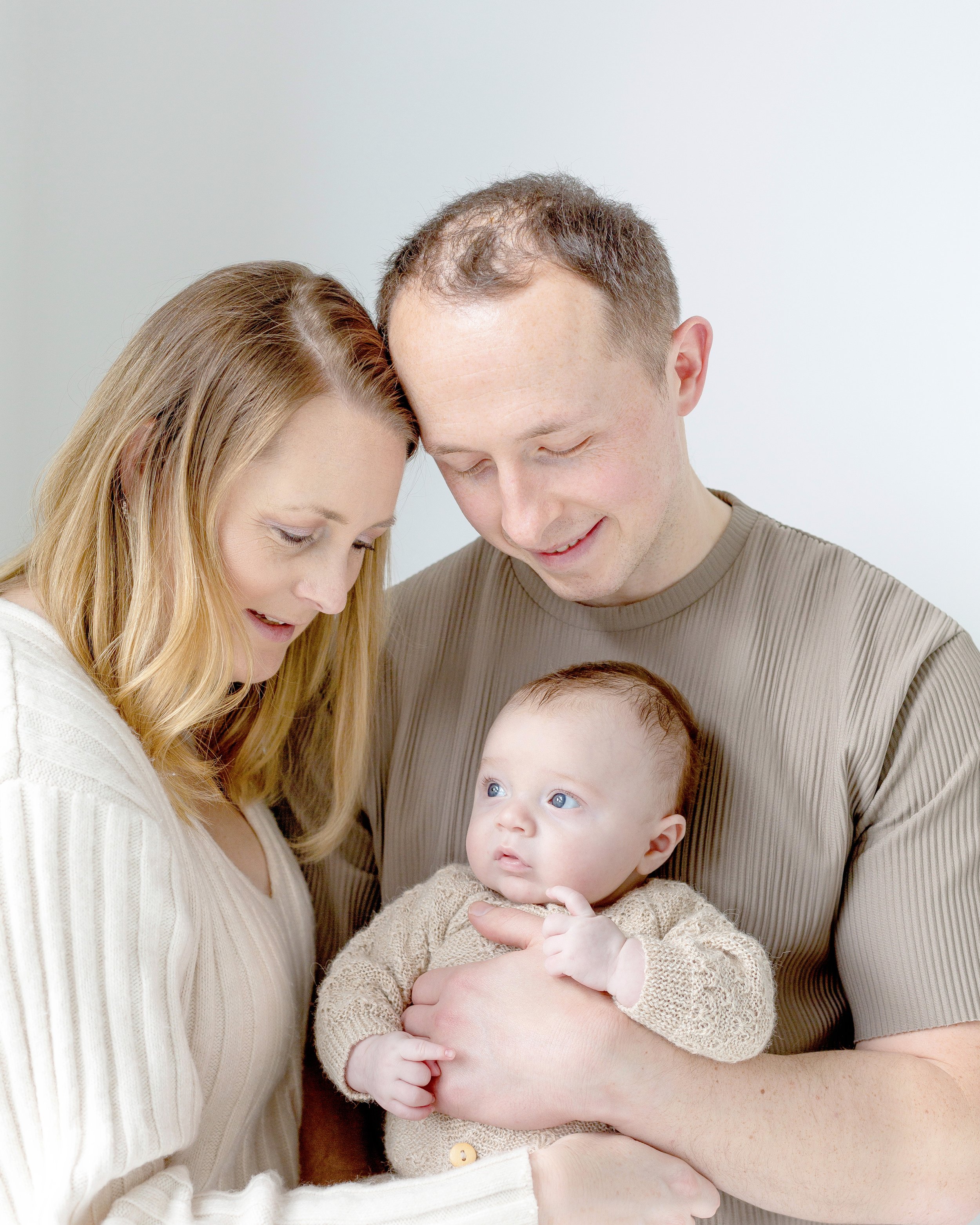 Family photograph all hugging looking at the baby