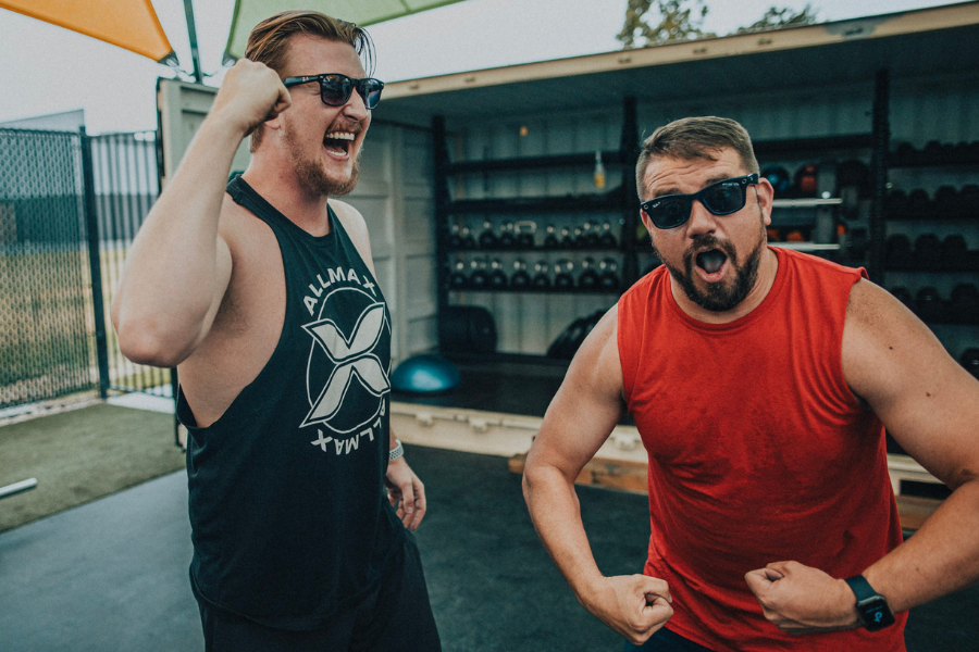 Two men celebrating after an outdoor strength workout at Club Apple gym in Idaho Falls