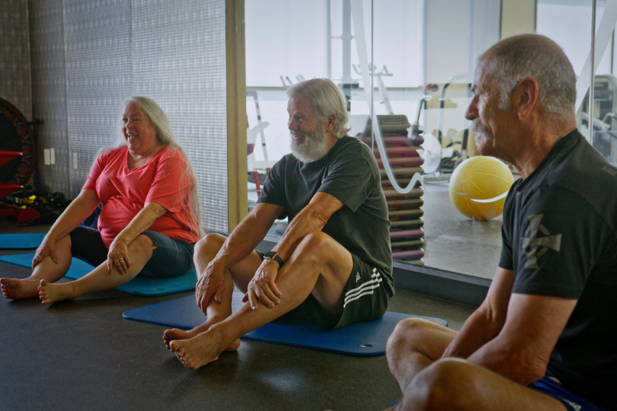 Active older adults participating in a senior fitness class on yoga mats at Club Apple health club in Idaho Falls