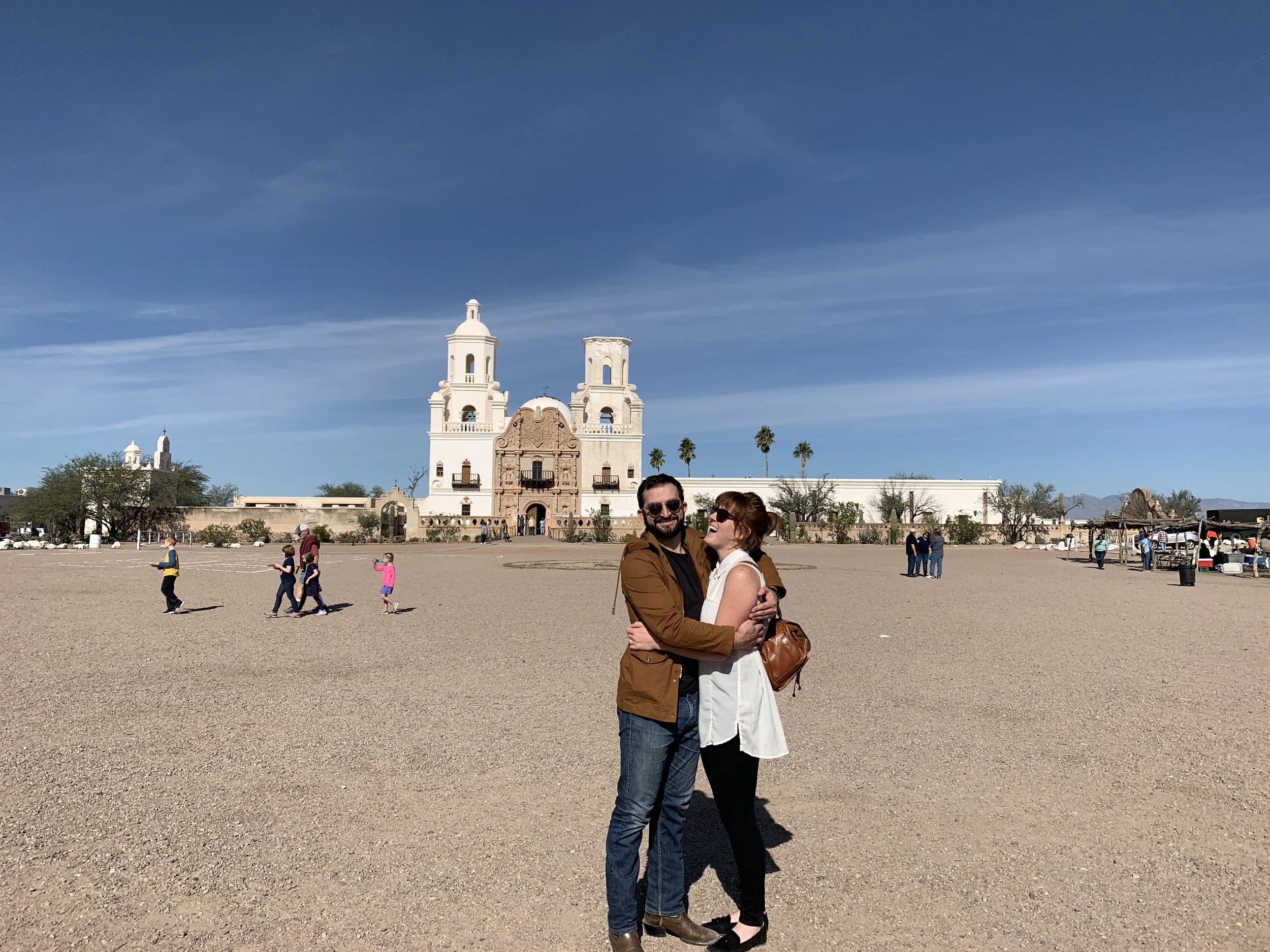 Company founders Tierra and Nick Izzo embracing in front of a cathedral