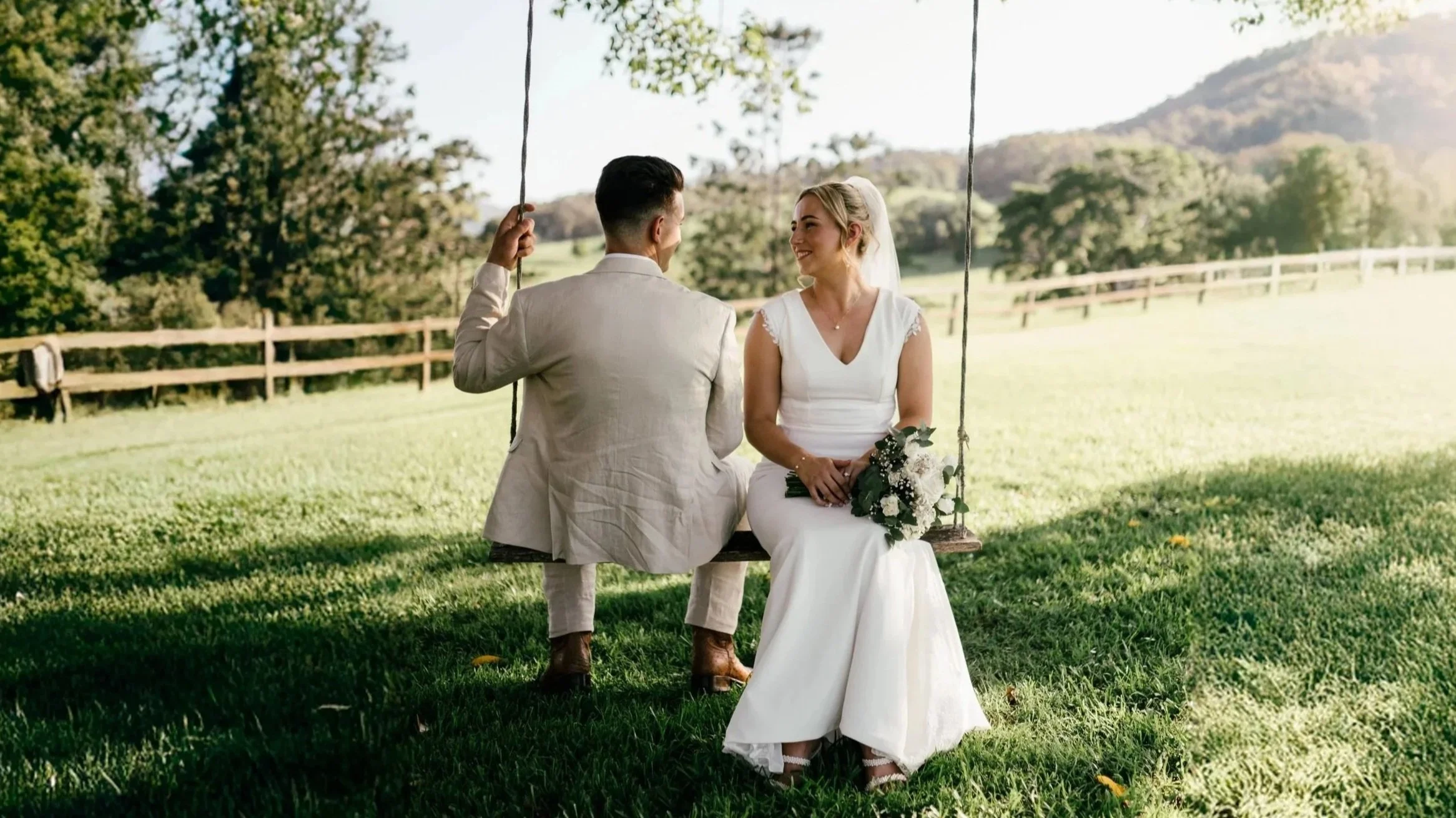 bride and groom sitting together on a swing chatting