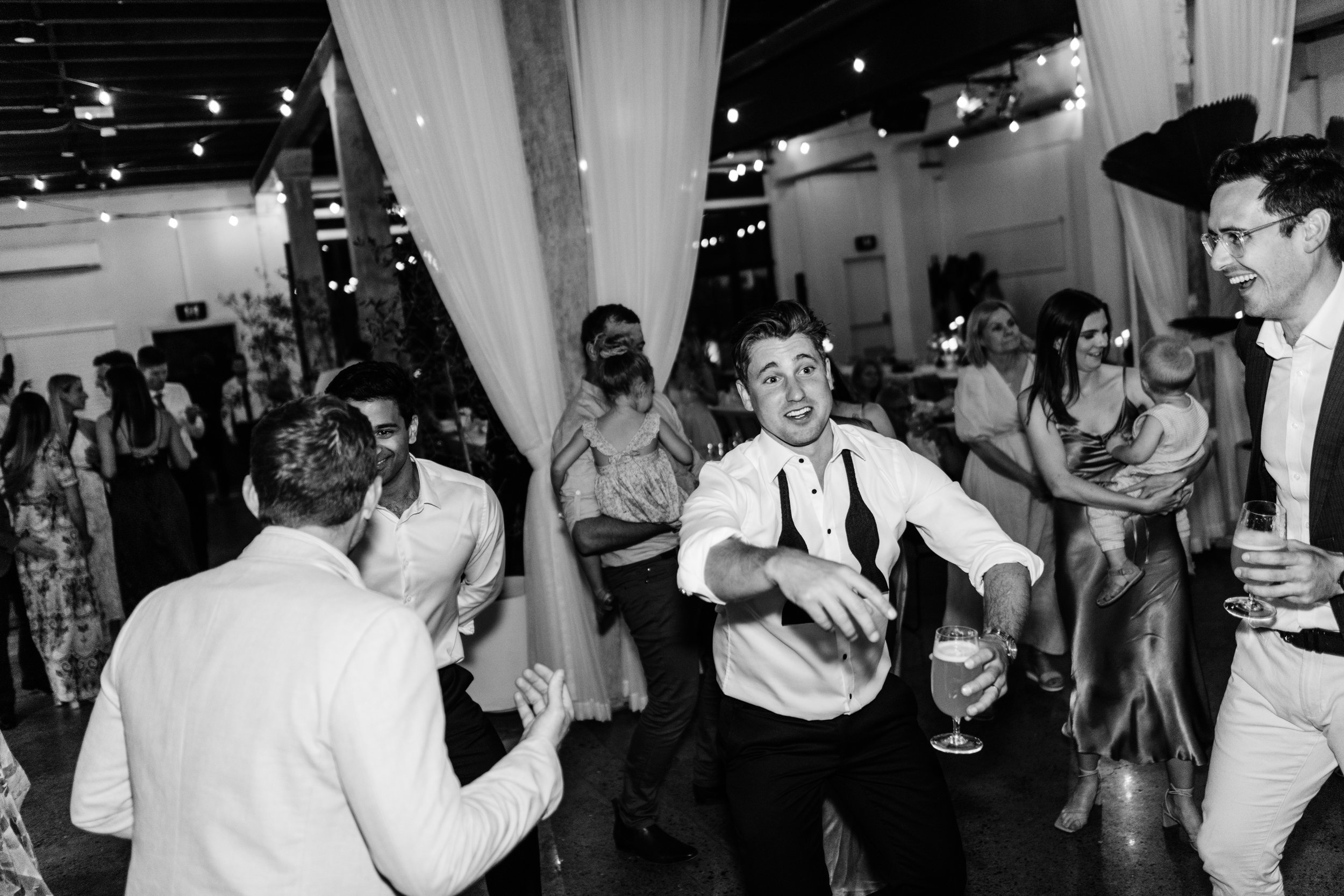 groom dancing with friends after wedding
