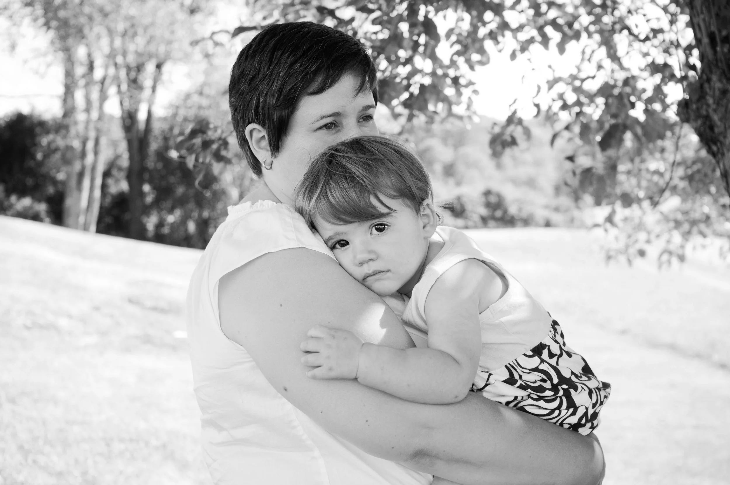 black and white photo of little girl resting in her mothers arms