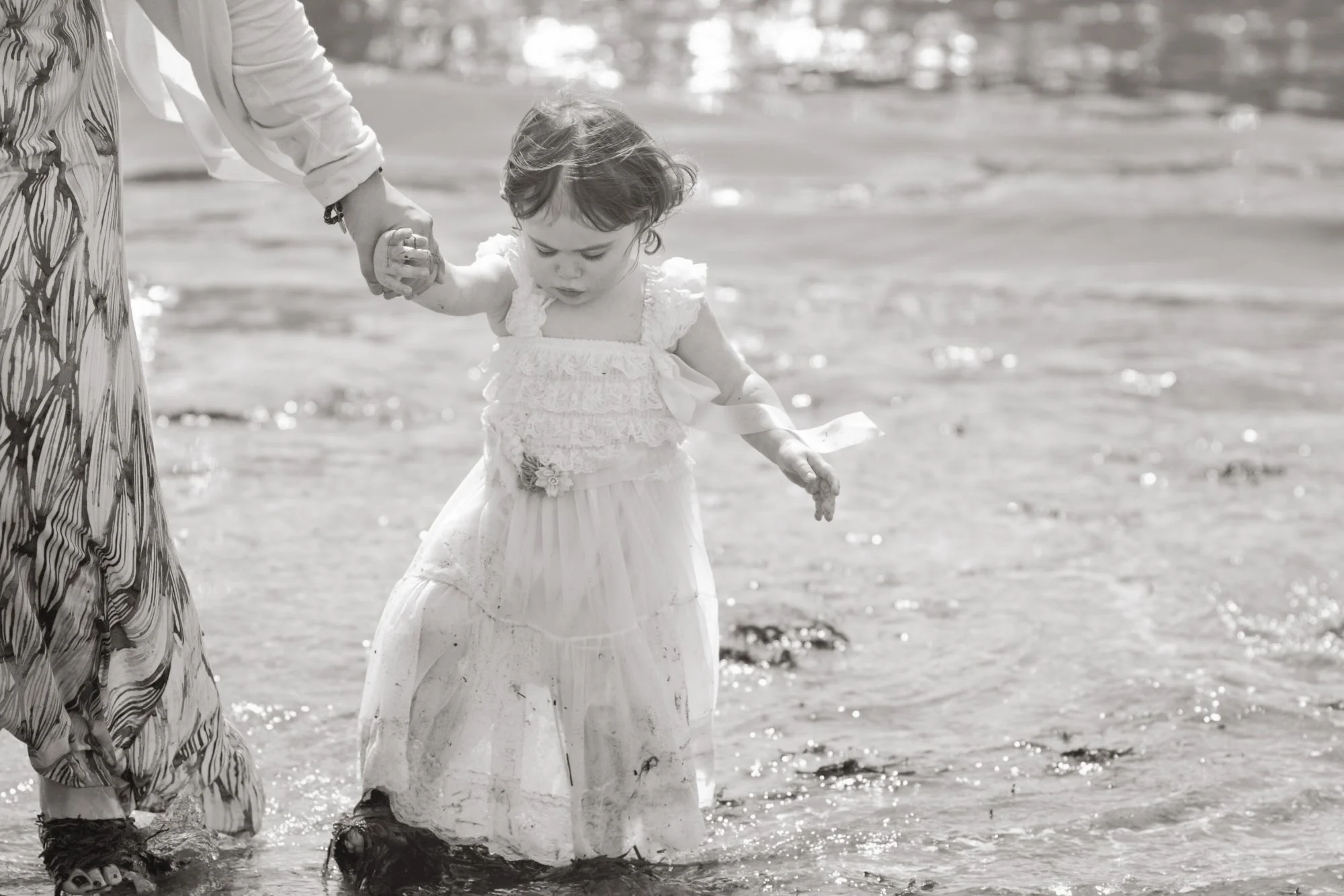 black and white photo of little girl on beach
