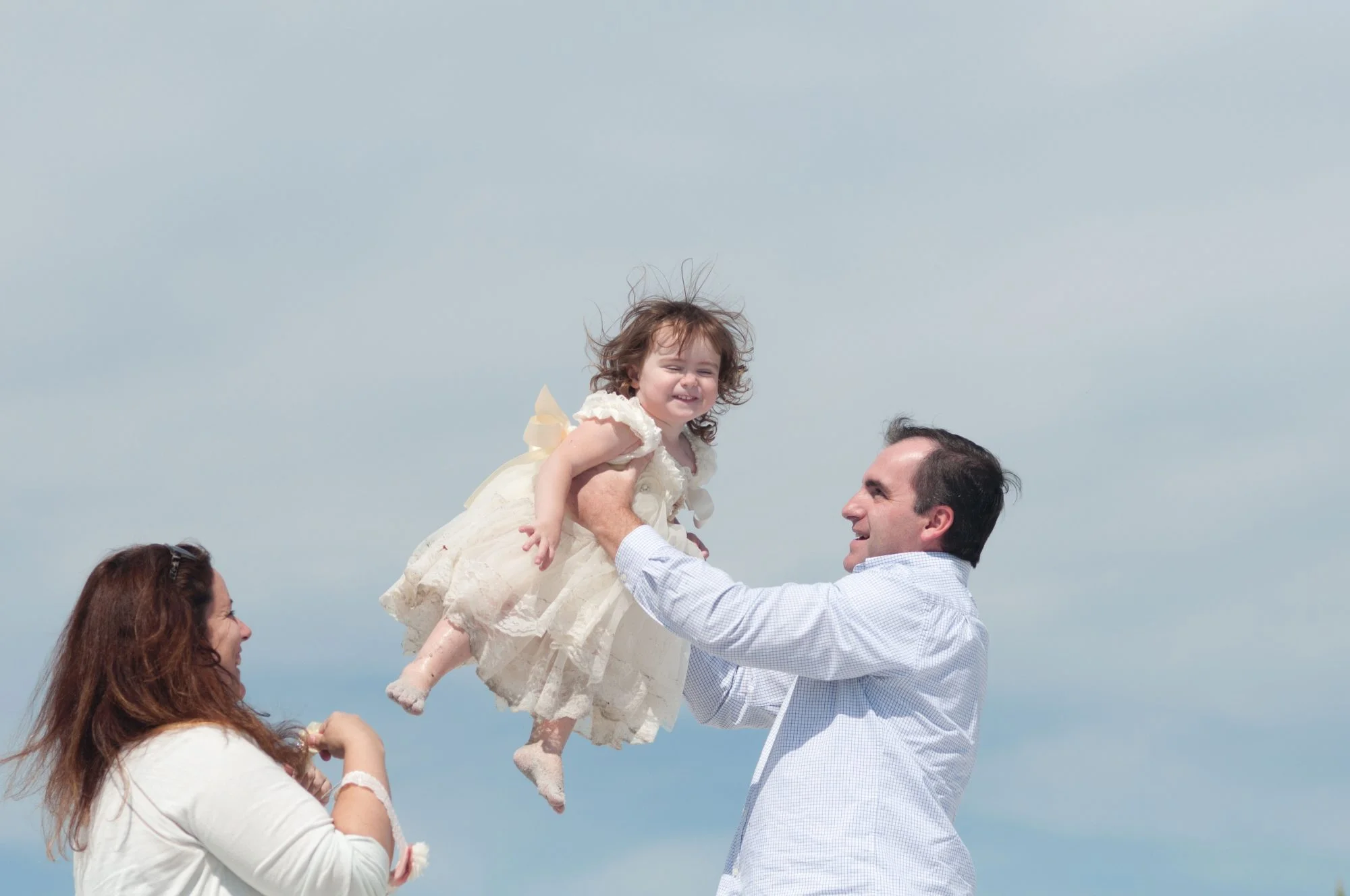 Father tossing his daughter into the air in a fun game.