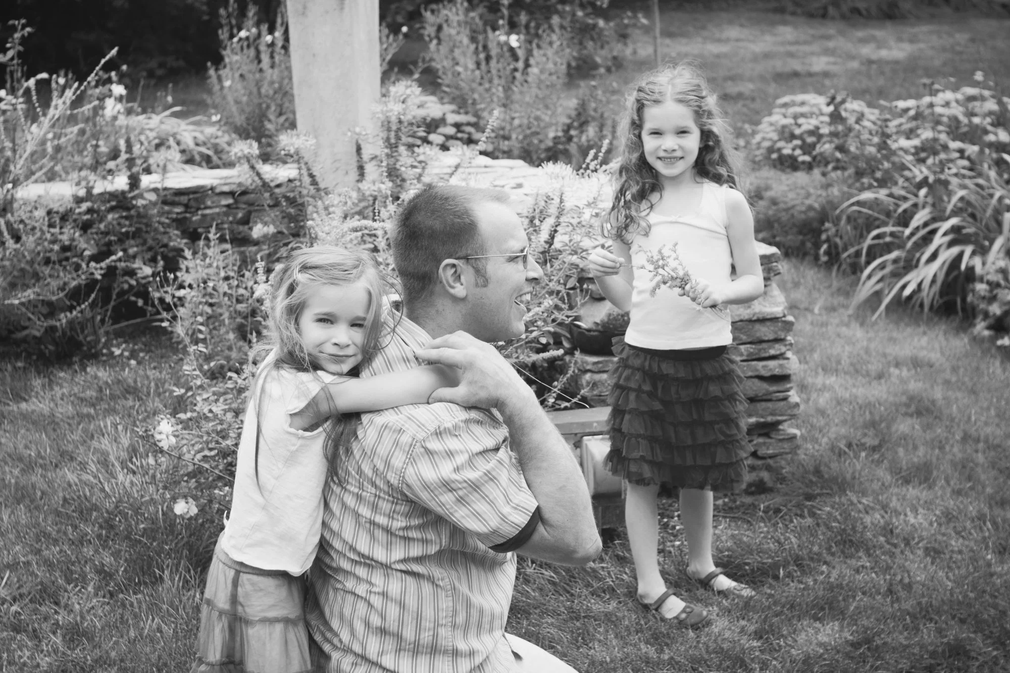 Black and white photo of father with two daughters