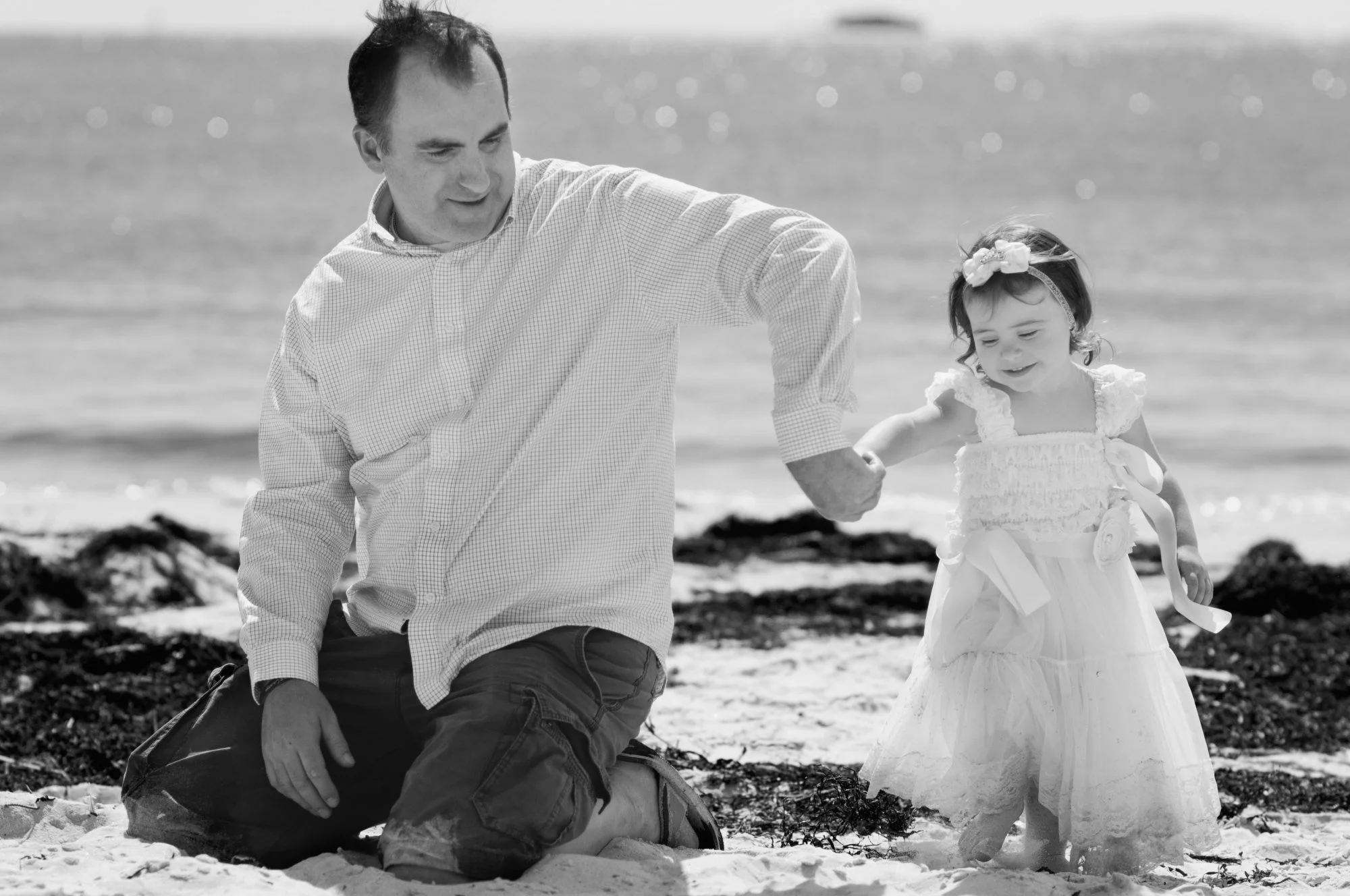 Father and daughter playing in the sand at Pemaquid Beach, Maine.