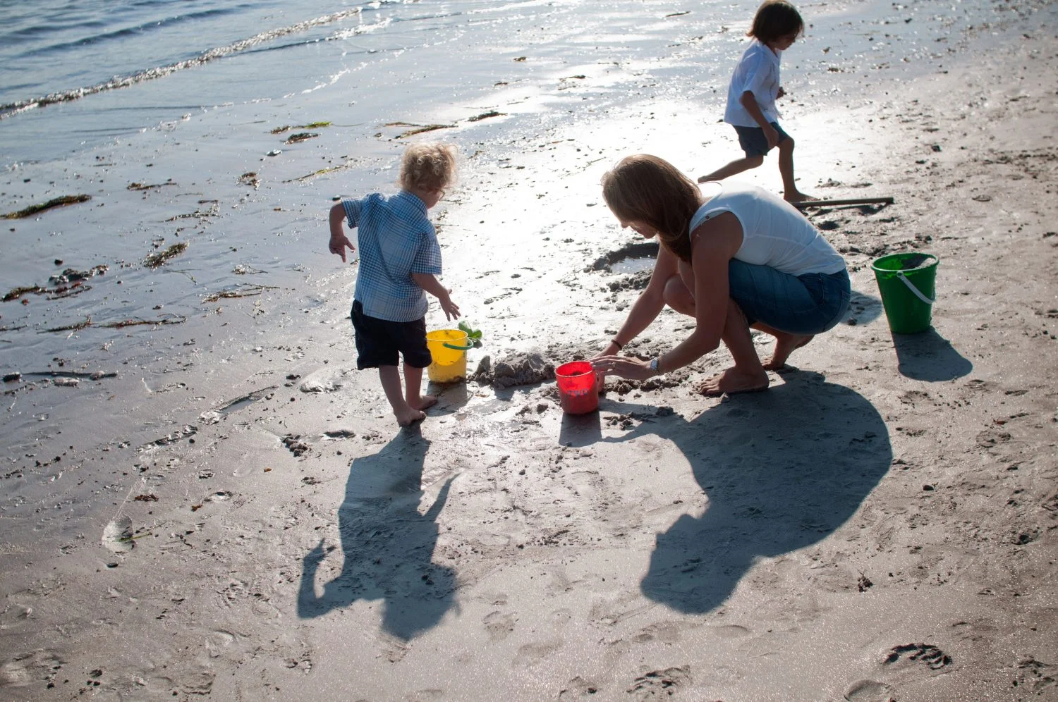 Mother and 2 sons playing in the sand at Pemaquid Beach