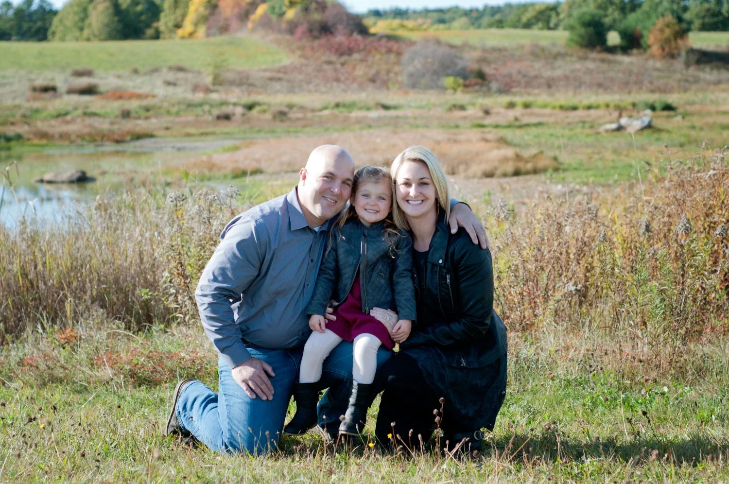 portrait of young family of 3 in an autum field