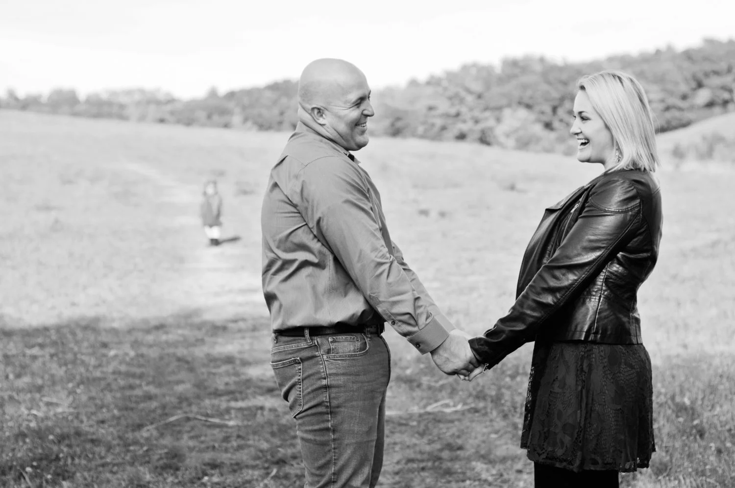 black and white portrait of young couple in a field