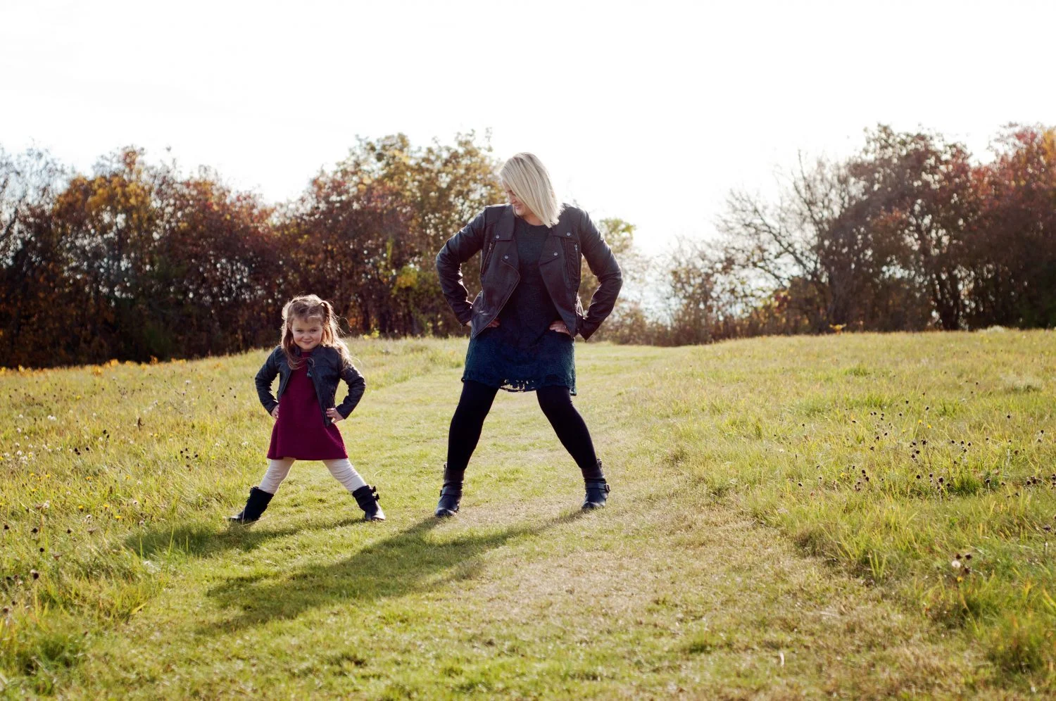 mother and daughter posing silly in a sunny field