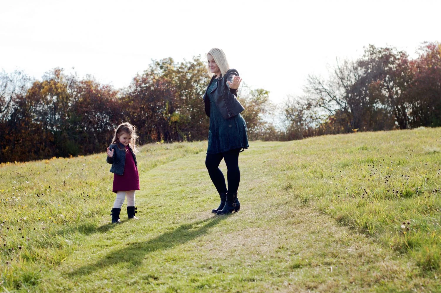 mother and daughter posing silly in a sunny field