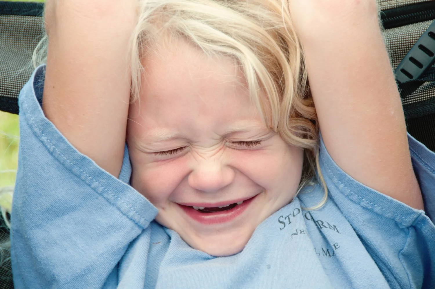little blonde girl with missing front teeth smiling with eyes closed