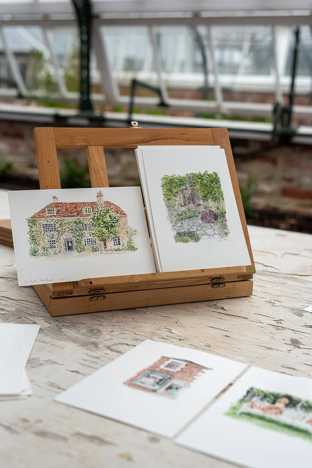 Beautiful watercolour illustrations of Charleston and a garden by Imogen Partridge. Sitting on a small tabletop wooden easel