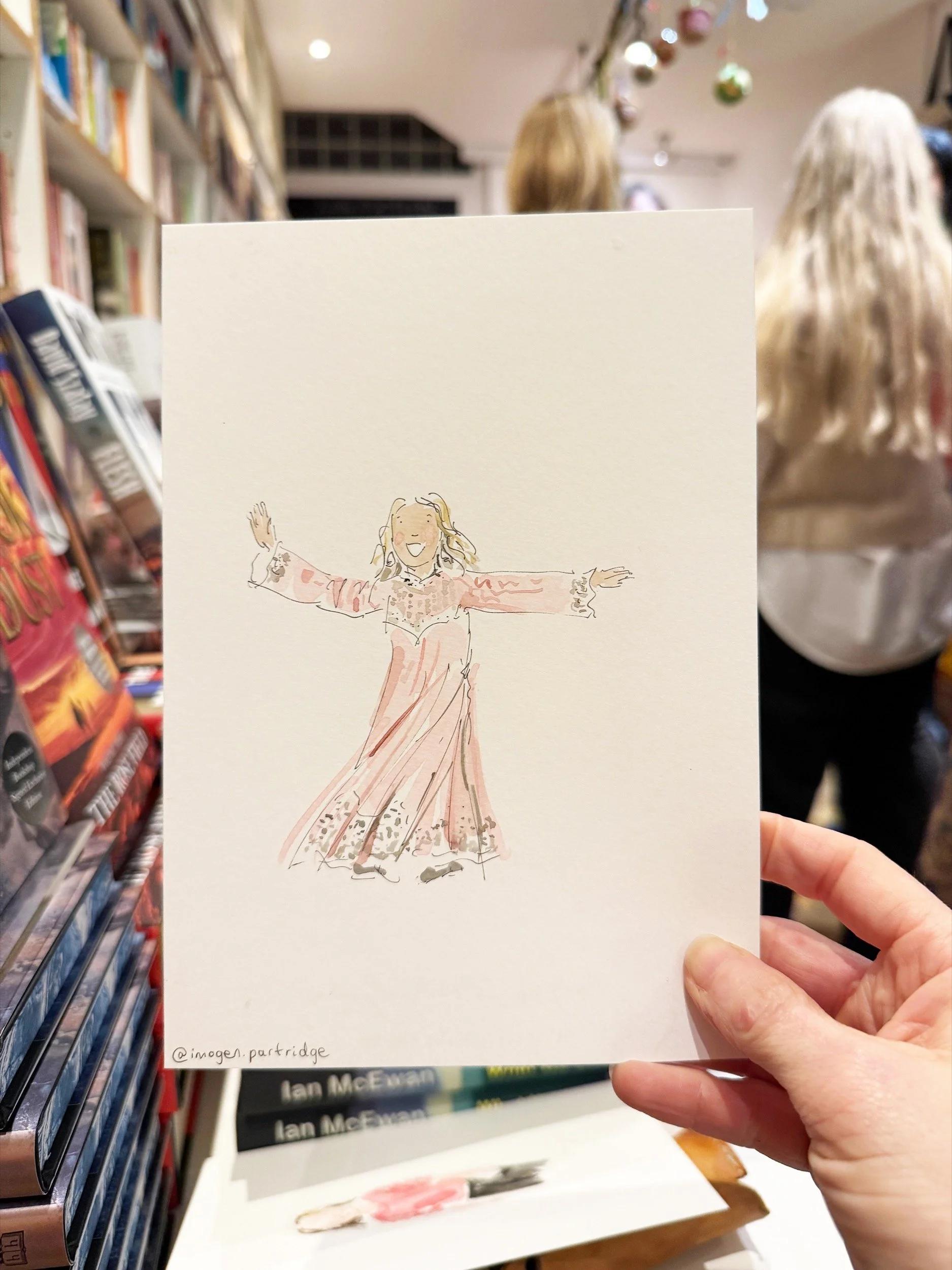 A brown lady dancing in a live event illustration with a pink dress, grey hair and brown skin, held up at an author event