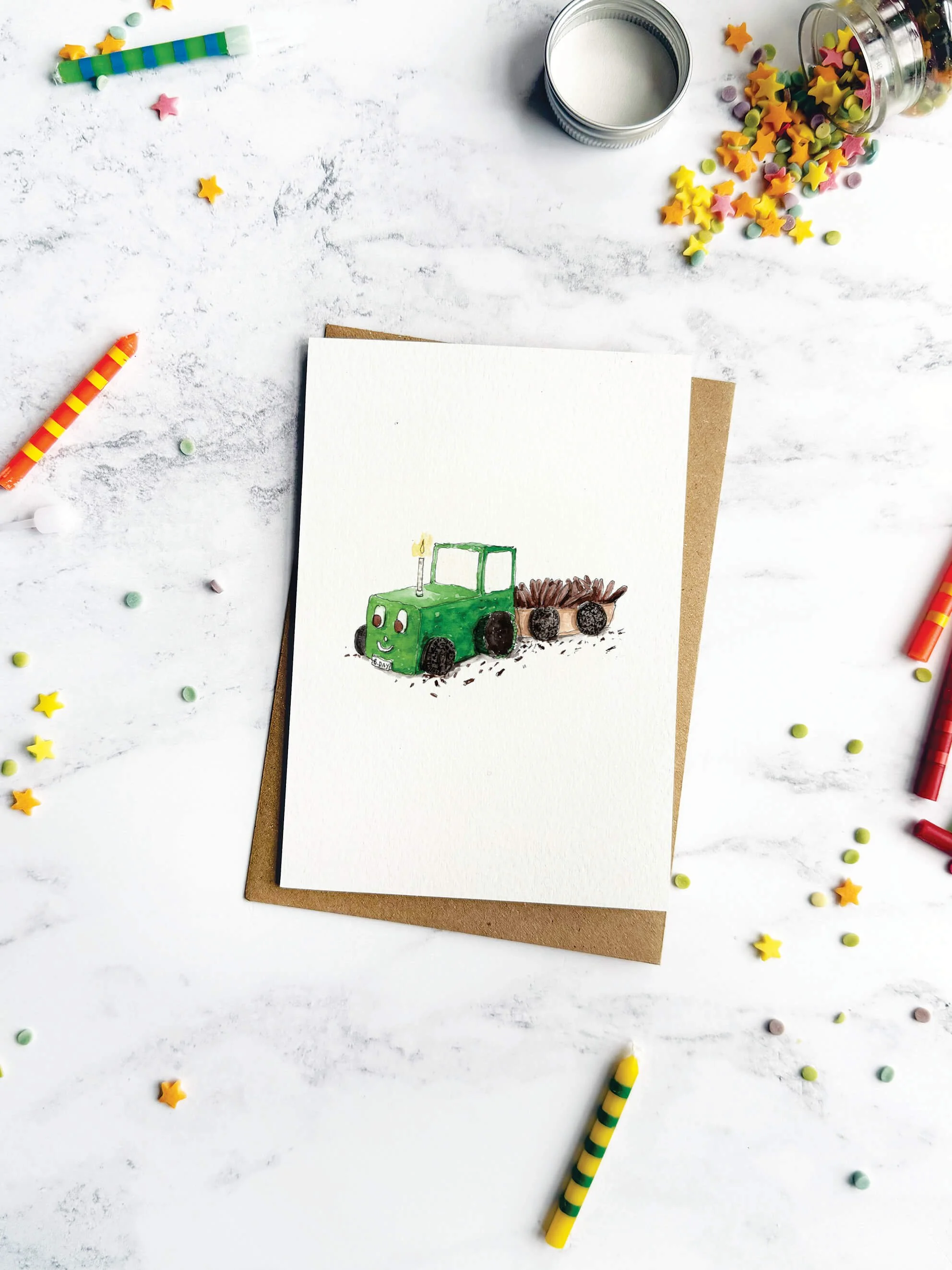 A playful birthday card featuring a nostalgic homemade cake, styled with colourful stripey candles and sprinkles on a marble backdrop.