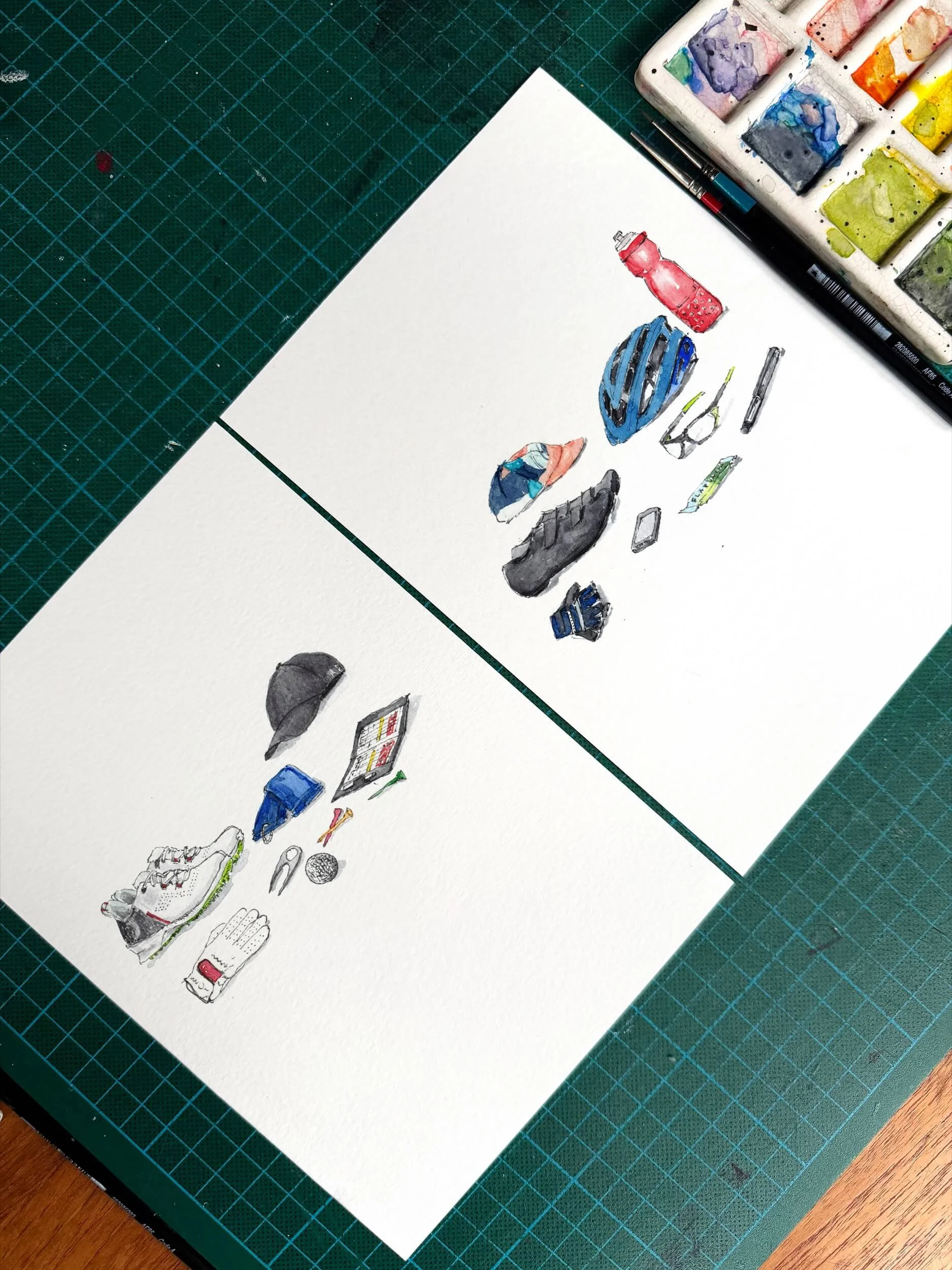 Beautiful golf and cycling illustration originals laid out on a table with a paint palette to the side. They sit on a green cutting mat background as if they have just been painted.