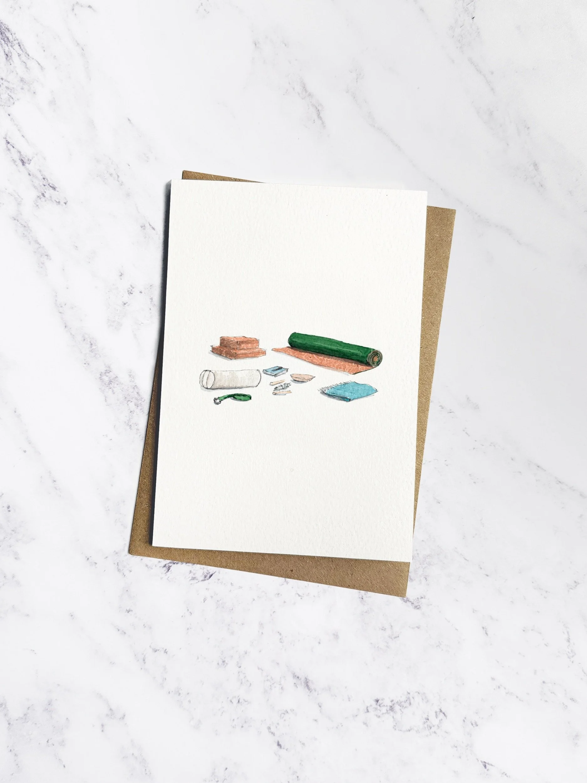 A serene yoga greetings card with delicate watercolour illustrations of a rolled-up yoga mat, blocks, a bolster, and a calming white sage bundle. Displayed on a marble background with Kraft envelope.