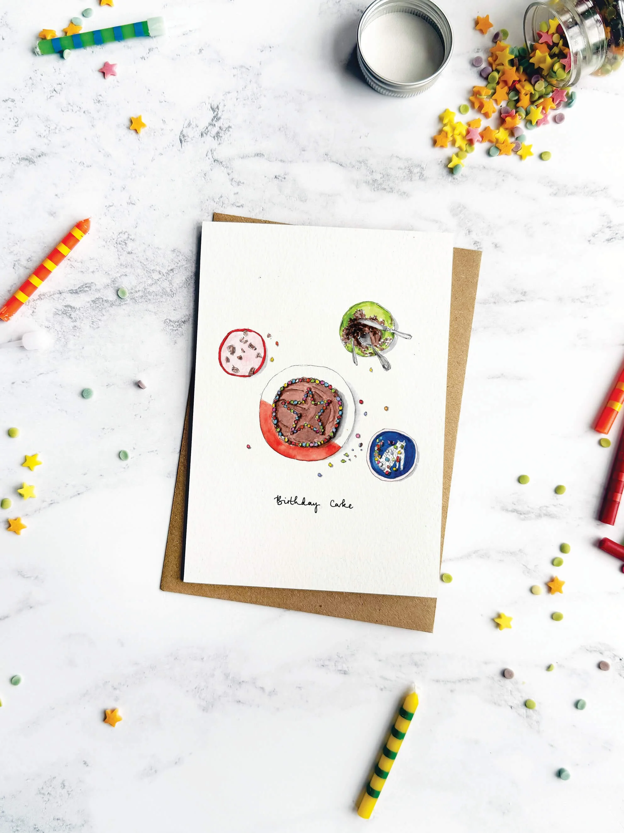 A nostalgic birthday card showing a homemade chocolate cake, surrounded by sprinkles and candles on a marble background.