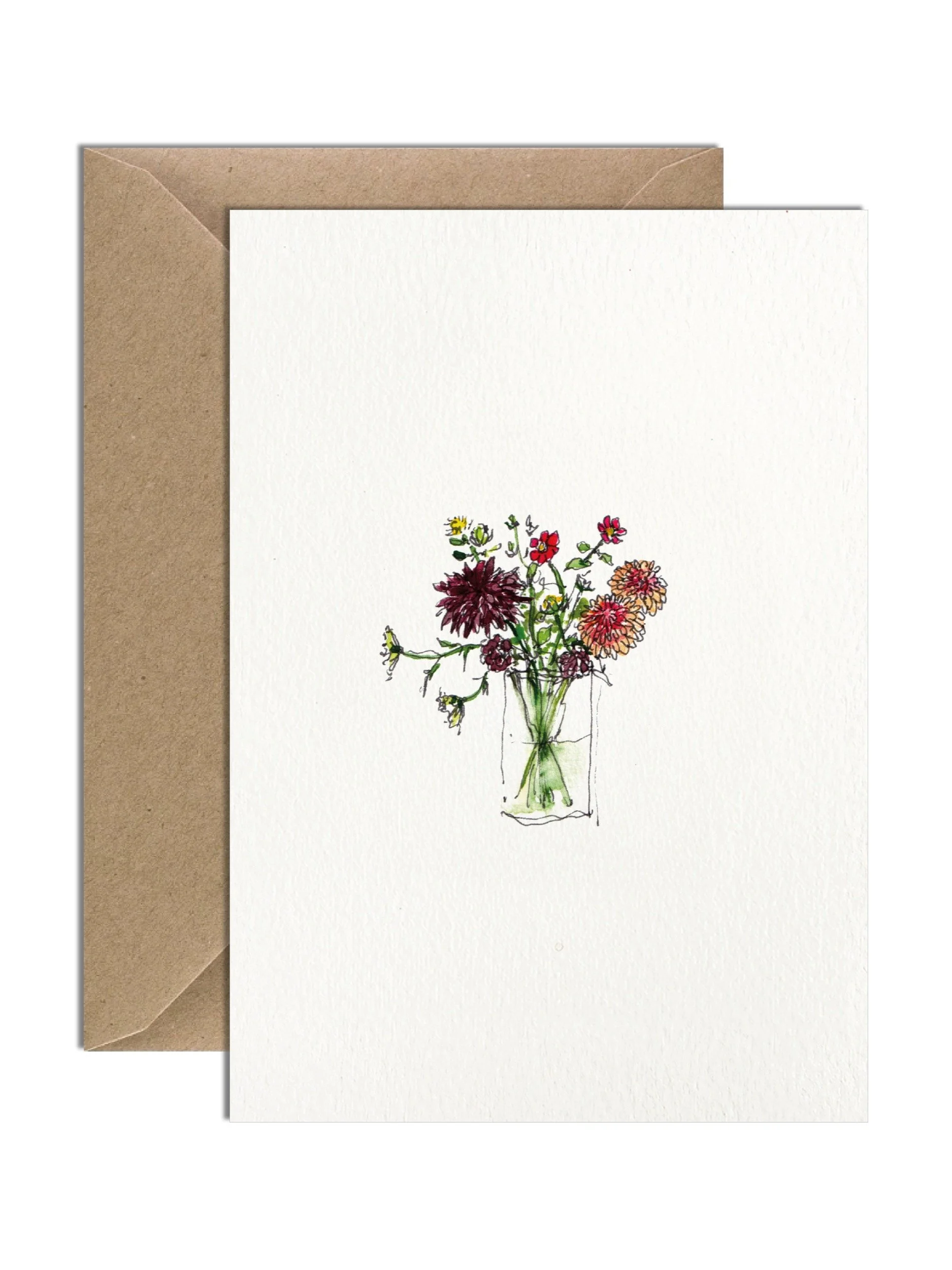 Warm coloured dahlias and other autumn flowers and foliage sitting in a glass vase. The card is on an off white lightly textured card with a brown kraft envelope behind.
