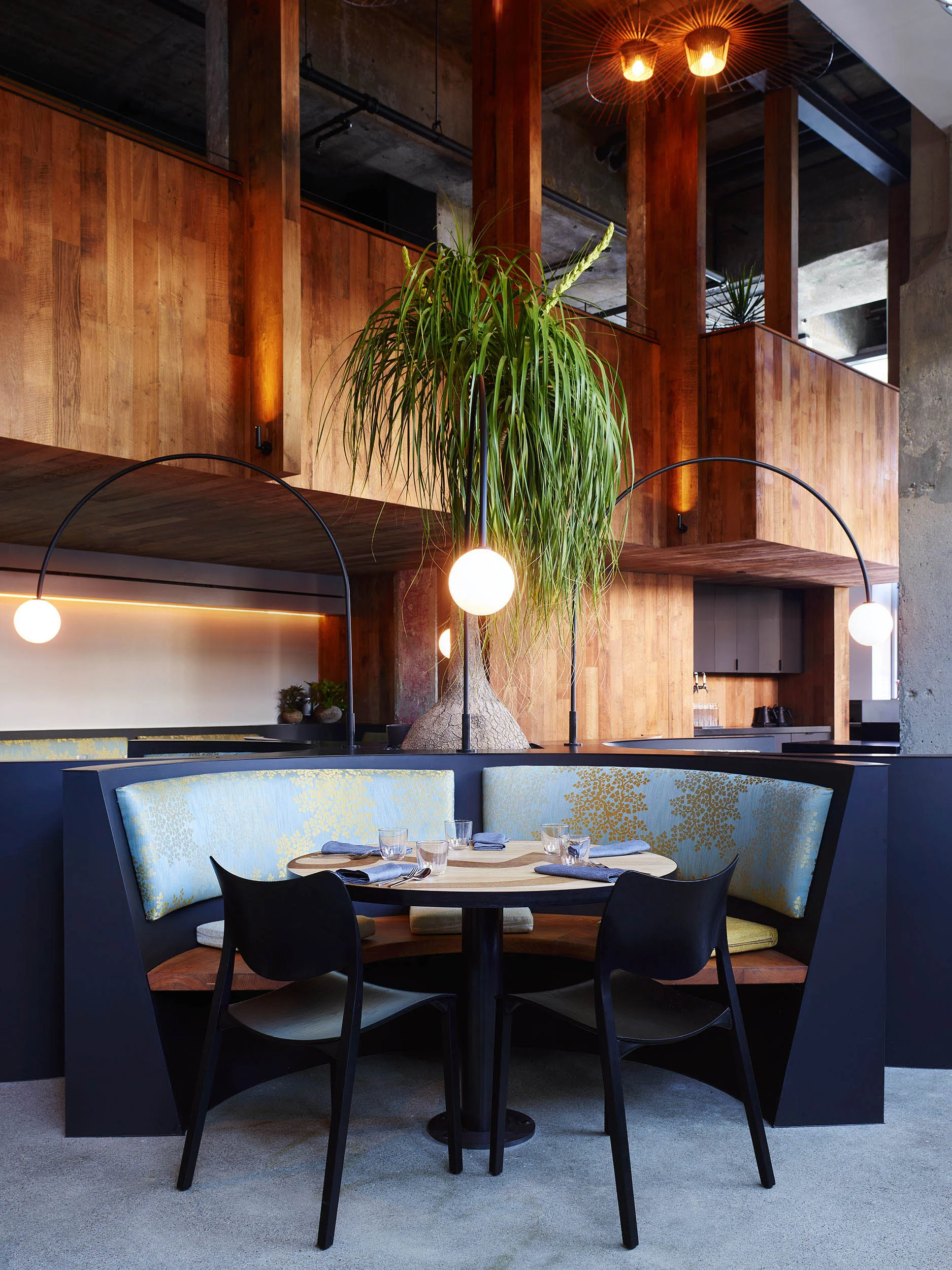 a semi-circular booth in the dinner room, flanked by greenery.jpg