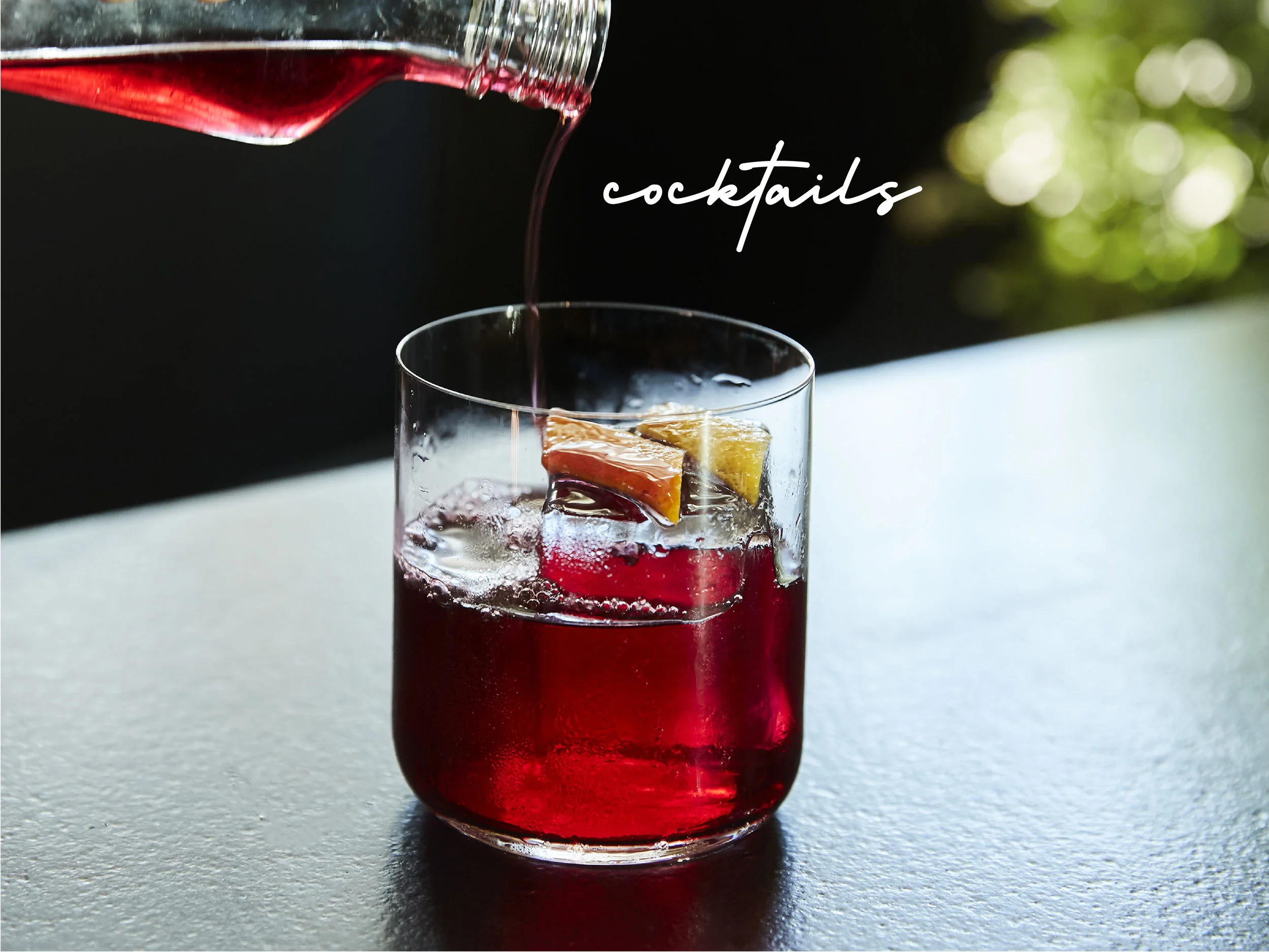 dark crimson lowball cocktail served over a large rock of ice.