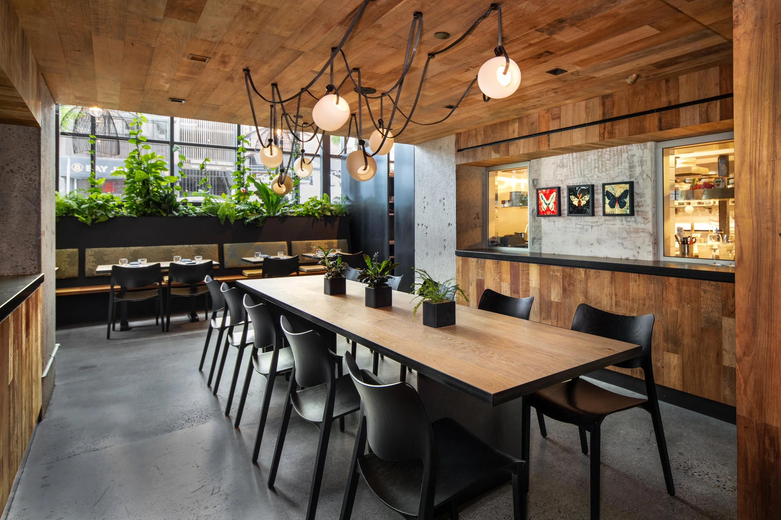 semi-private dining area features and long wooden top table (large enough for 10) with a fun, whimsical, deconstructed chandelier.