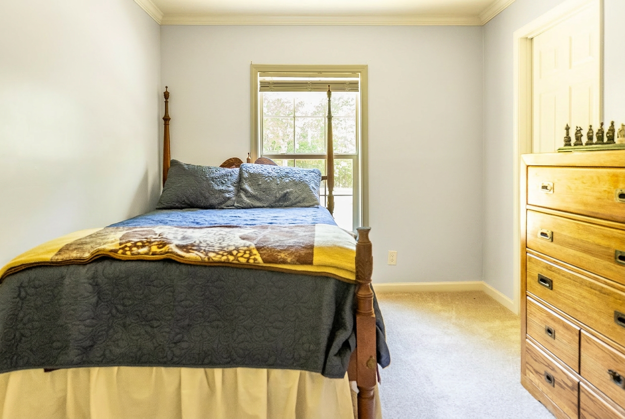 Light_Gray_Walls_A_neat_bedroom_features_a_wooden_bed_with_a_dark_E6qdMaIp.png