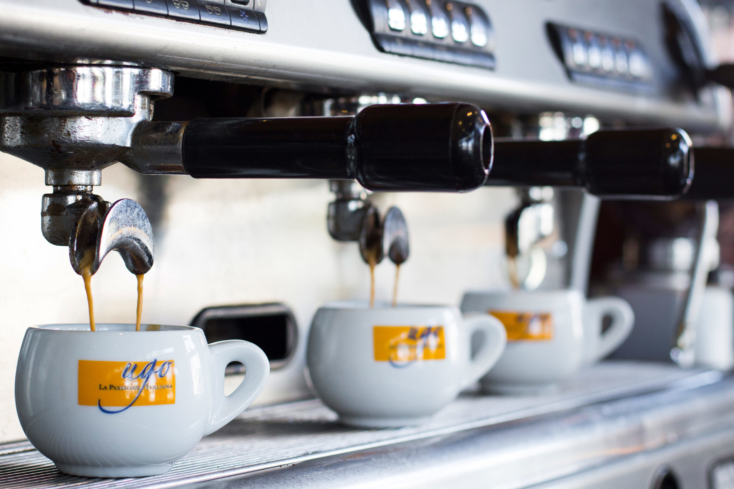 coffee machine pours into several Ugo mugs