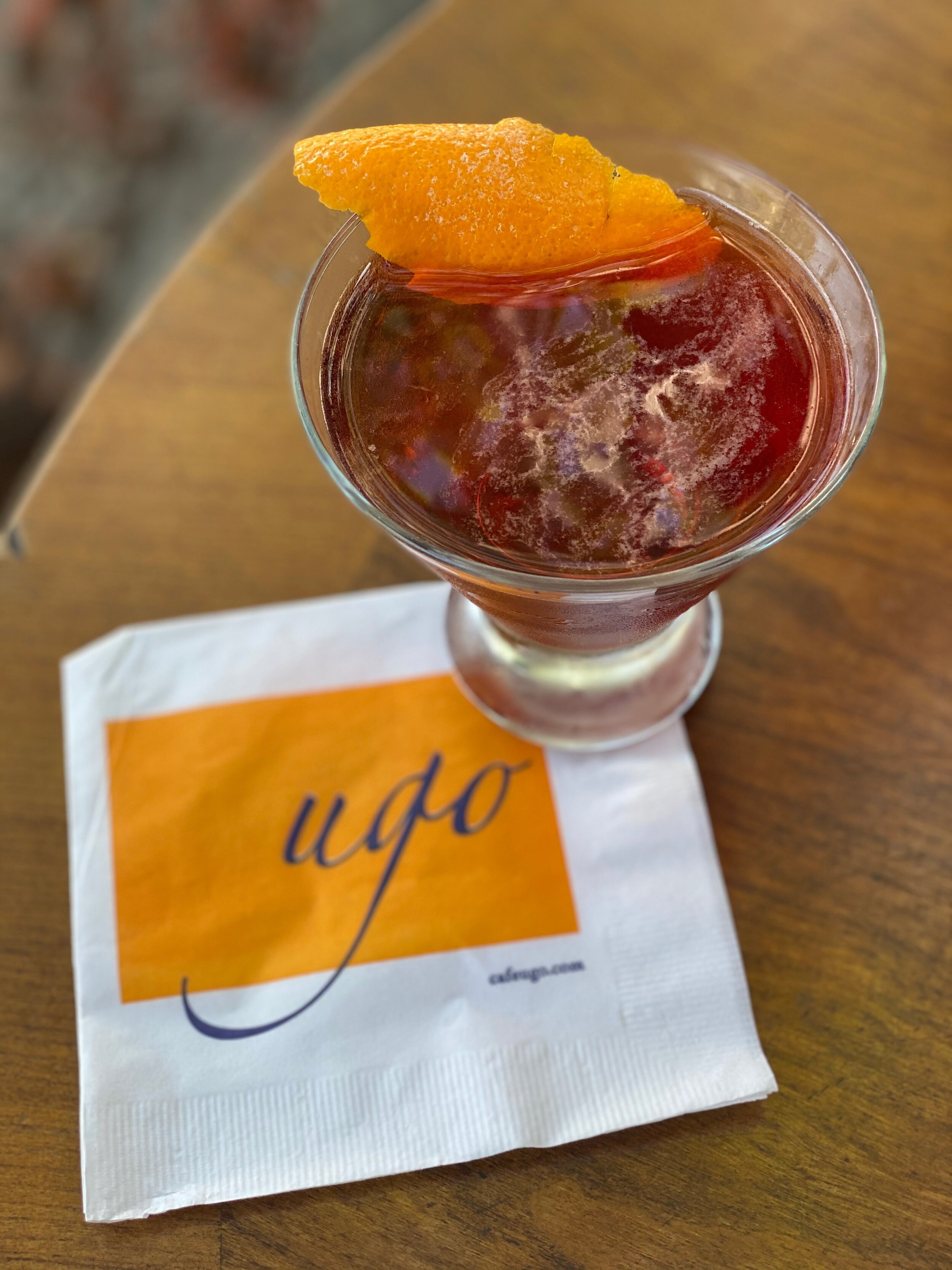 cocktail with orange rind sits on Ugo napkin
