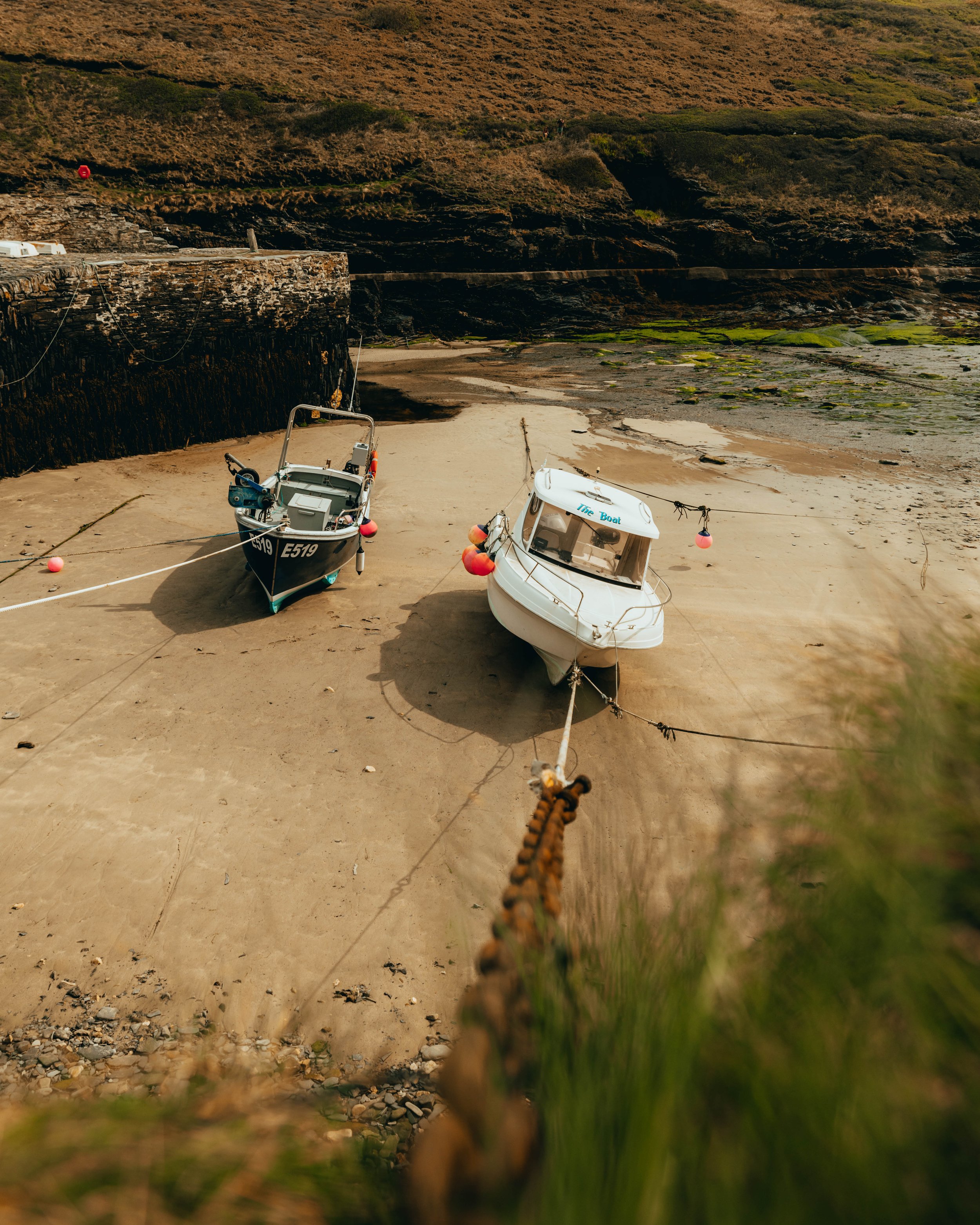 Two boats on the sand with the tide out at Boscastle Harbour