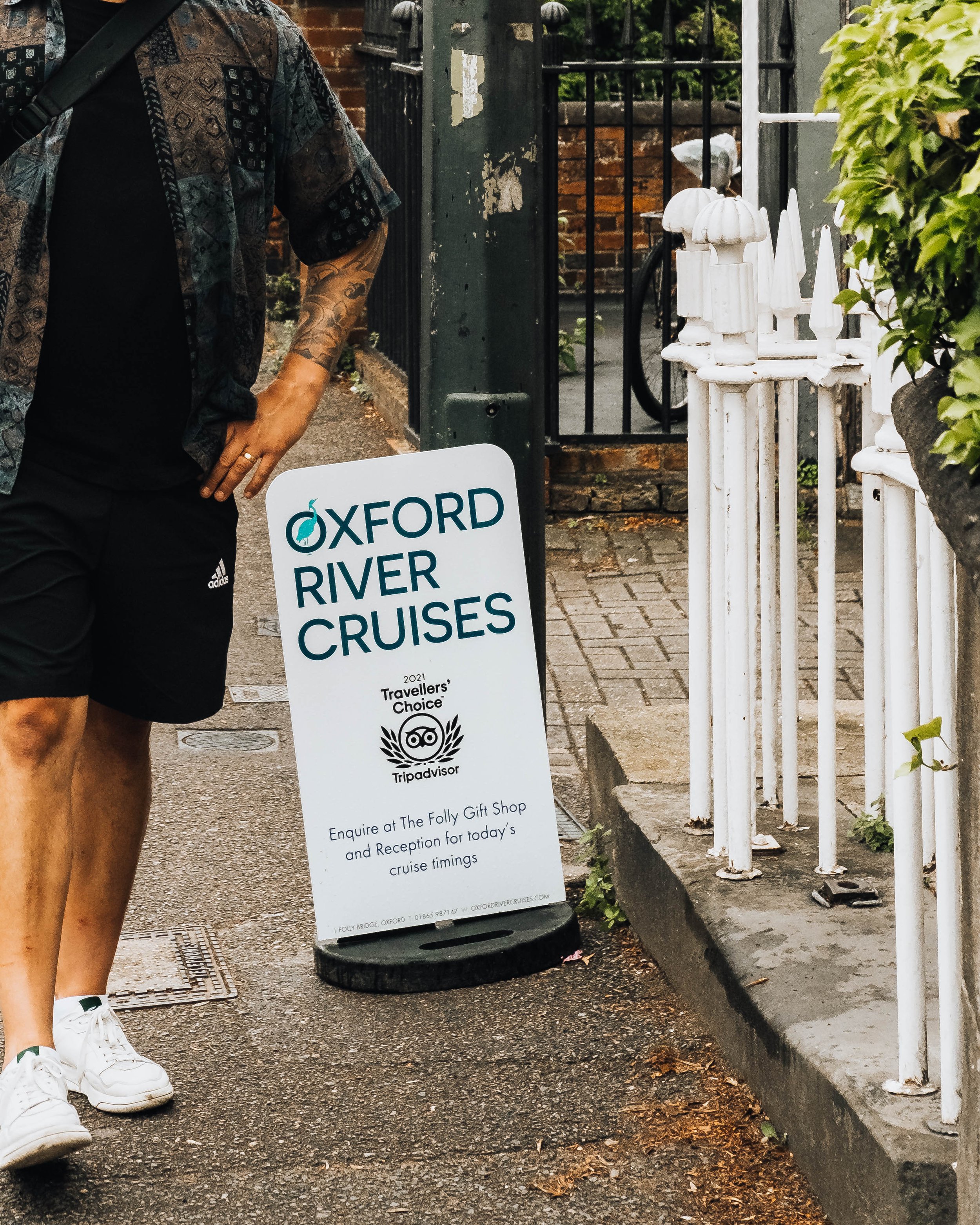 Man standing by a sign saying Oxford River Cruises