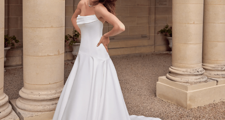 Bride modeling one of the modern minimalist wedding dresses with a strapless neckline and clean fit-and-flare silhouette.