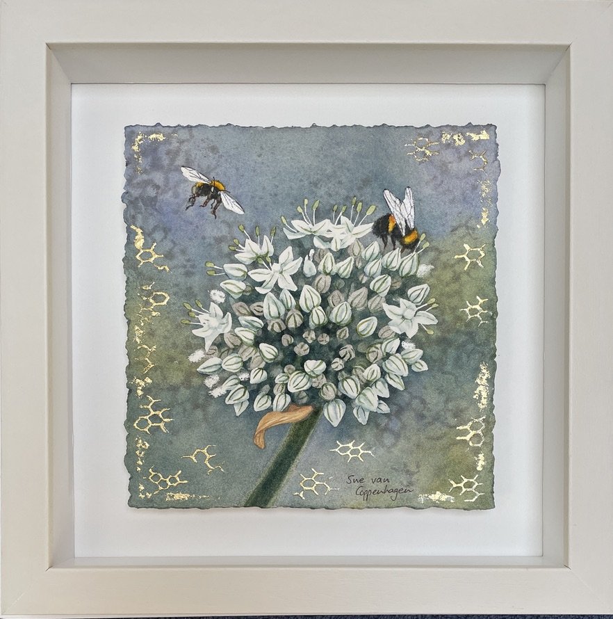 Framed painting of a white allium flower and two bumble bees, with gold patterns of honeycomb cells