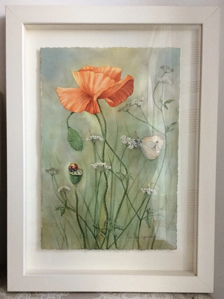 Framed painting of a red poppy on a green background with a white butterfly and a ladybird