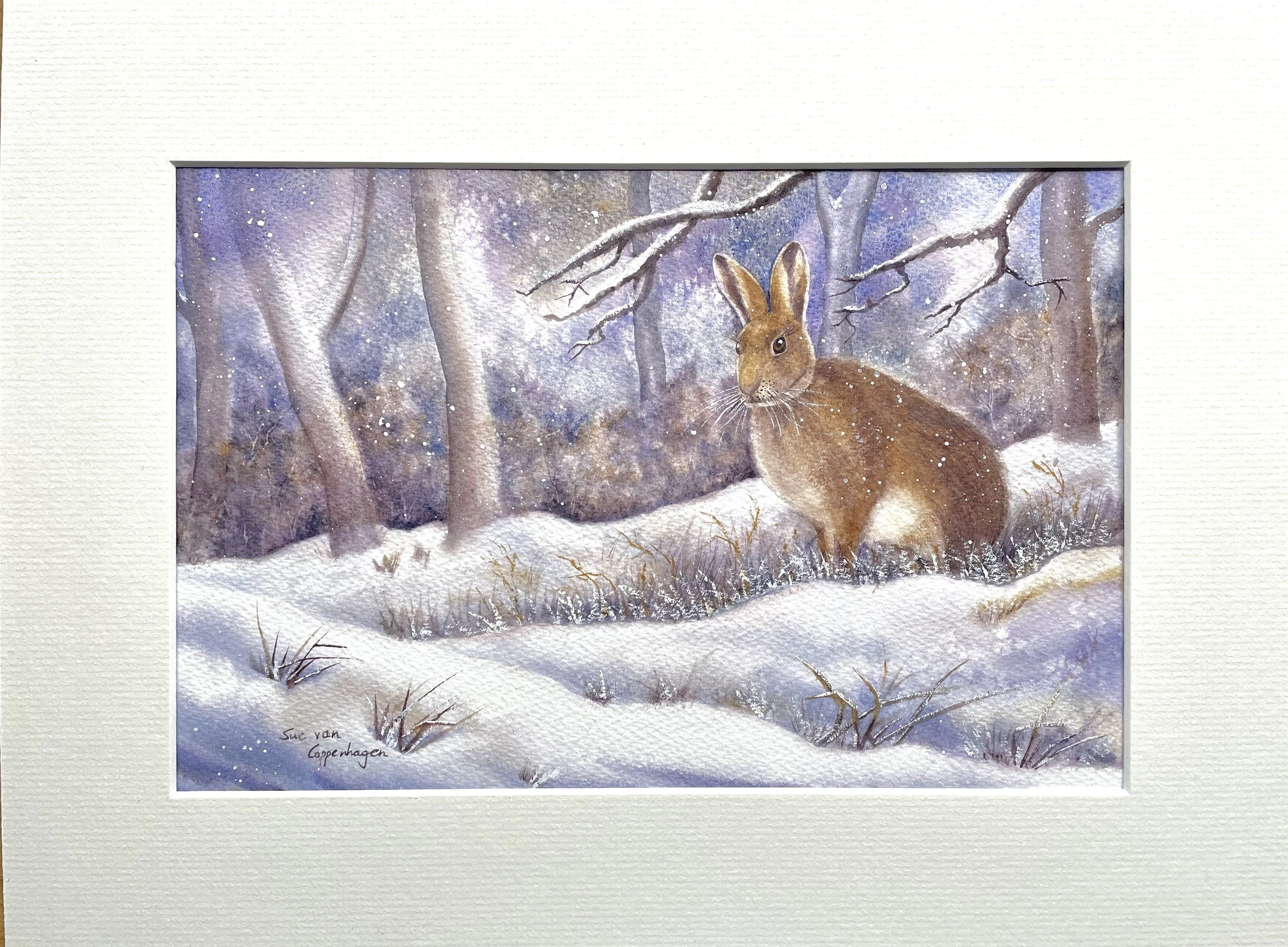 Mounted watercolour painting of a brown hare in a snowy woodland