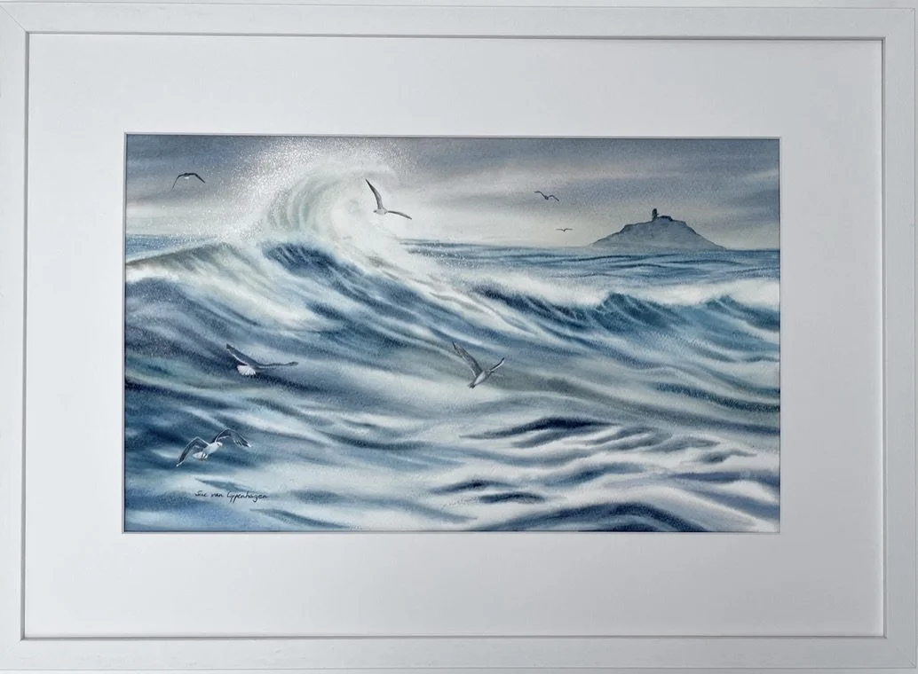 Painting in an off-white frame of a seascape with waves, spray and gulls swirling in front of Ballycotton island