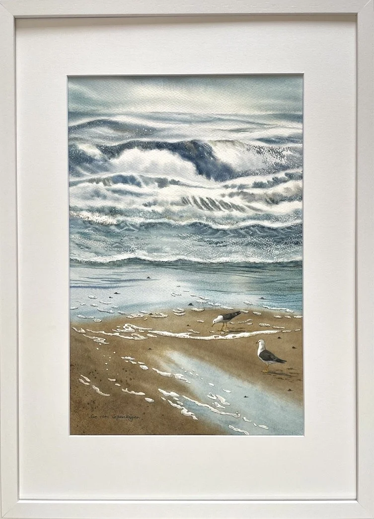 Watercolour seascape with waves, wet sands, drifts of foam and two gulls in an off-white frame