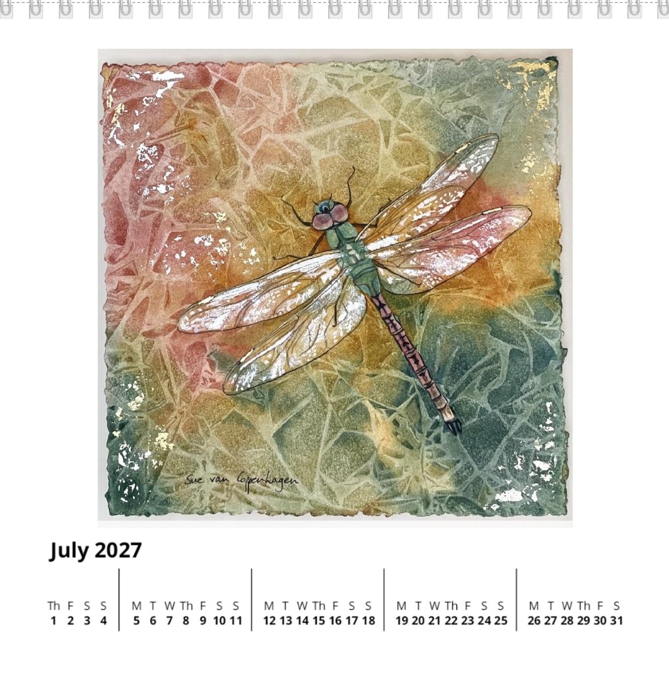 July page of a square standing calendar with dates below a square painting of a dragonfly on a gold, red and green background with cellular shapes and touches of gold